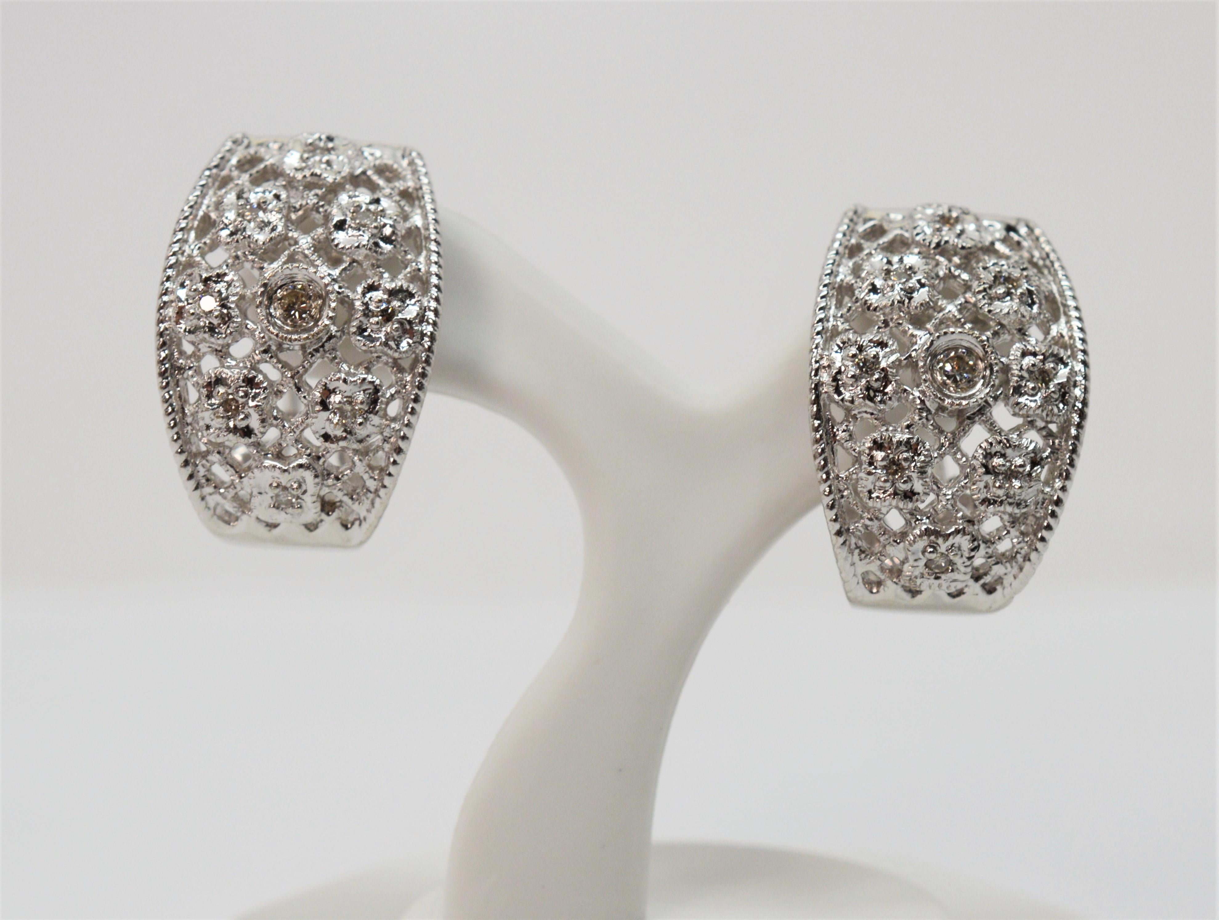 Fanciful, these tasteful eighteen karat 18k white gold lattice filigree wide oval hoop earrings sparkle with faceted round diamond accents. Made for pierced ears with post backs and an omega closure, they measure approximately 3/4 inches long and