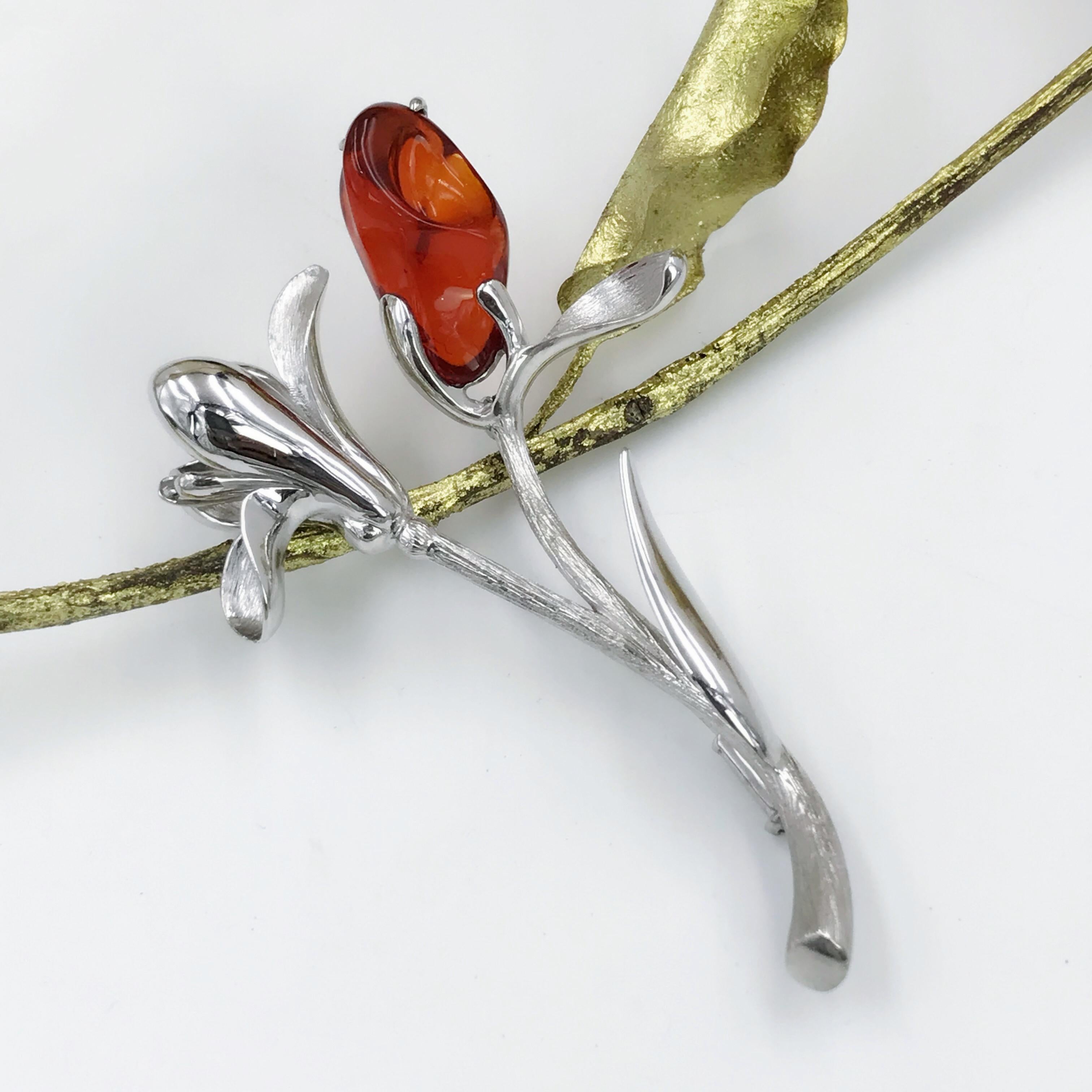 An 18 Karat white gold flower brooch. Design as a Magnolia blossom, set with a good quality fire opal, finished with brushed and polished effect. Metal is marked as 18ct gold. total length of brooch is 5.8cm. 