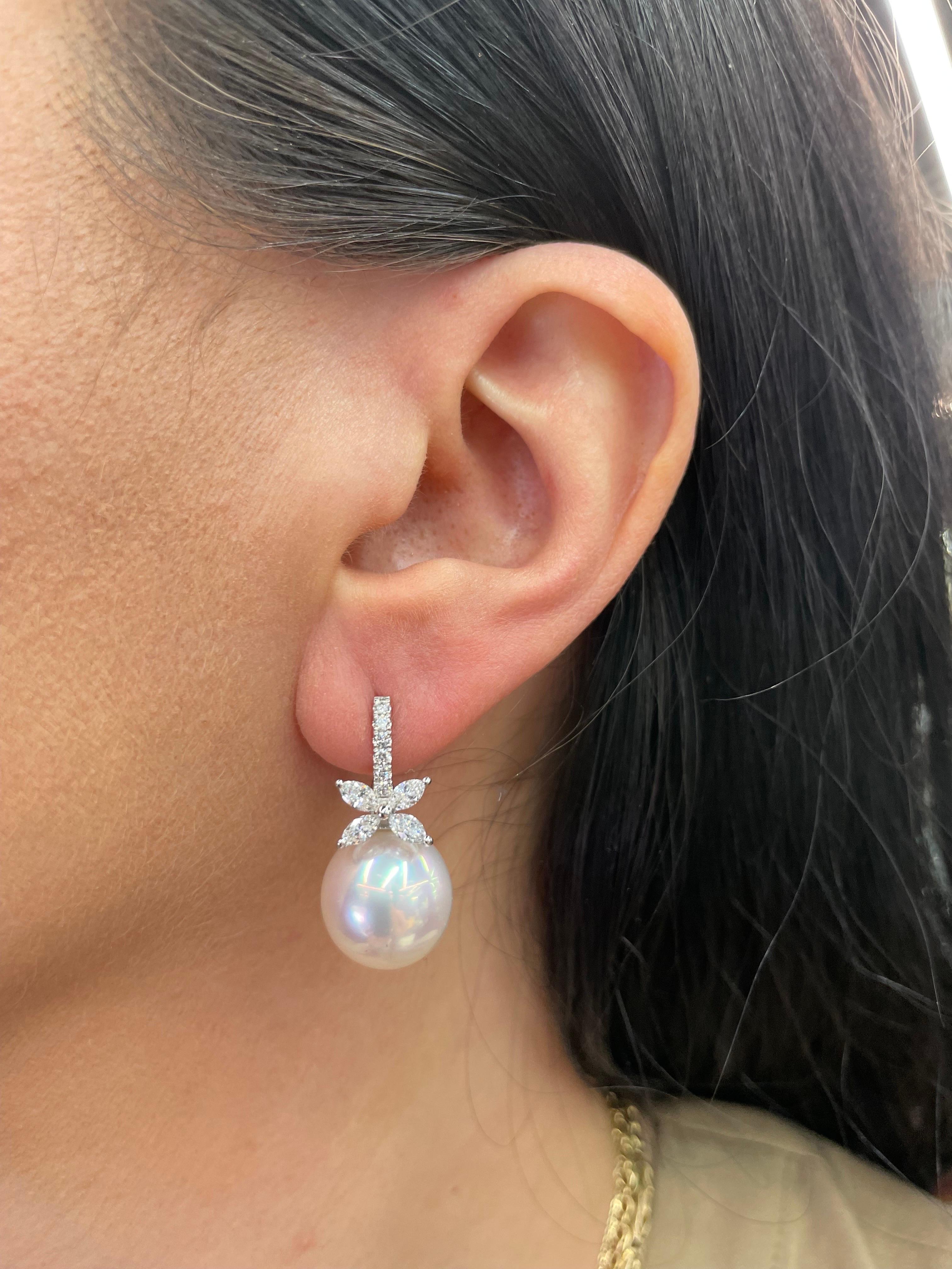 18 Karat White gold drop earrings featuring a diamond floral motif with 8 Marquise Diamonds weighing 0.79 Carats, 13 round brilliants weighing 0.17 carats and two South Sea Pearls measuring 13-14 MM
Color G-H
Clarity SI

Pearls can be changed to