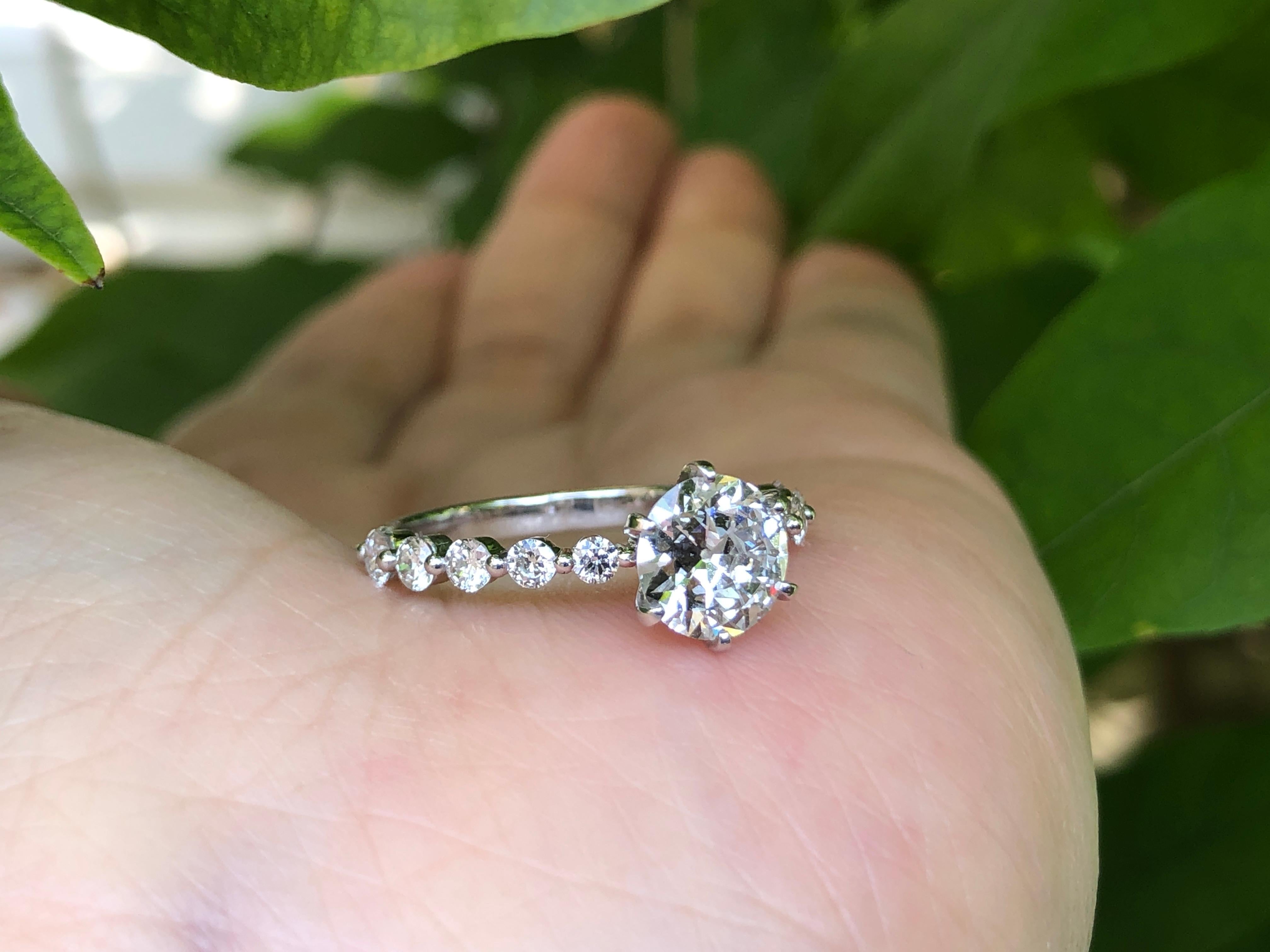 An unusual 18K white gold solitaire diamond ring that was in the 190s classic style. It has just under a carat brilliant old cut diamond in the centre. It is a good clear bright white stone with GIA certification. On either side set into the