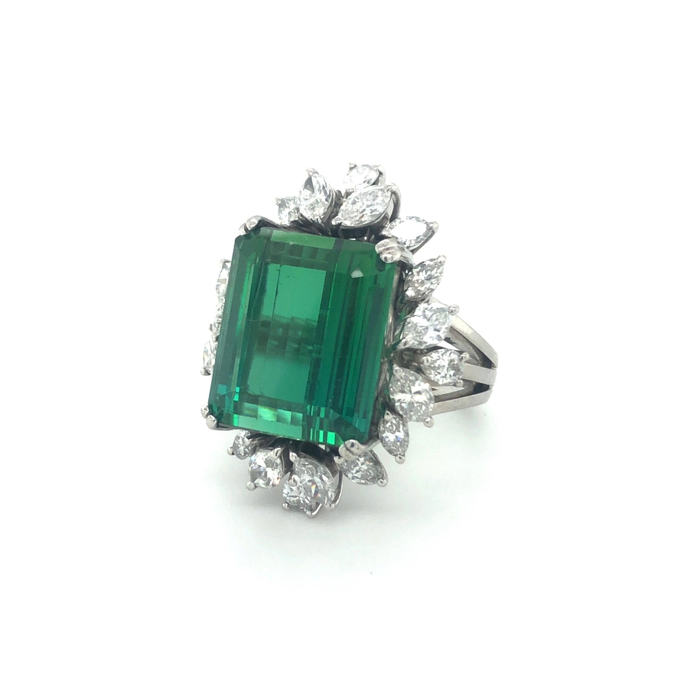 18 karat white gold green tourmaline diamond cocktail ring.
Splendid cocktail ring set with a vivid green octagonal tourmaline of circa 13 carats surrounded by an harmoniously arranged entourage consisting of 4 pear-shape and 16 marquise-shape