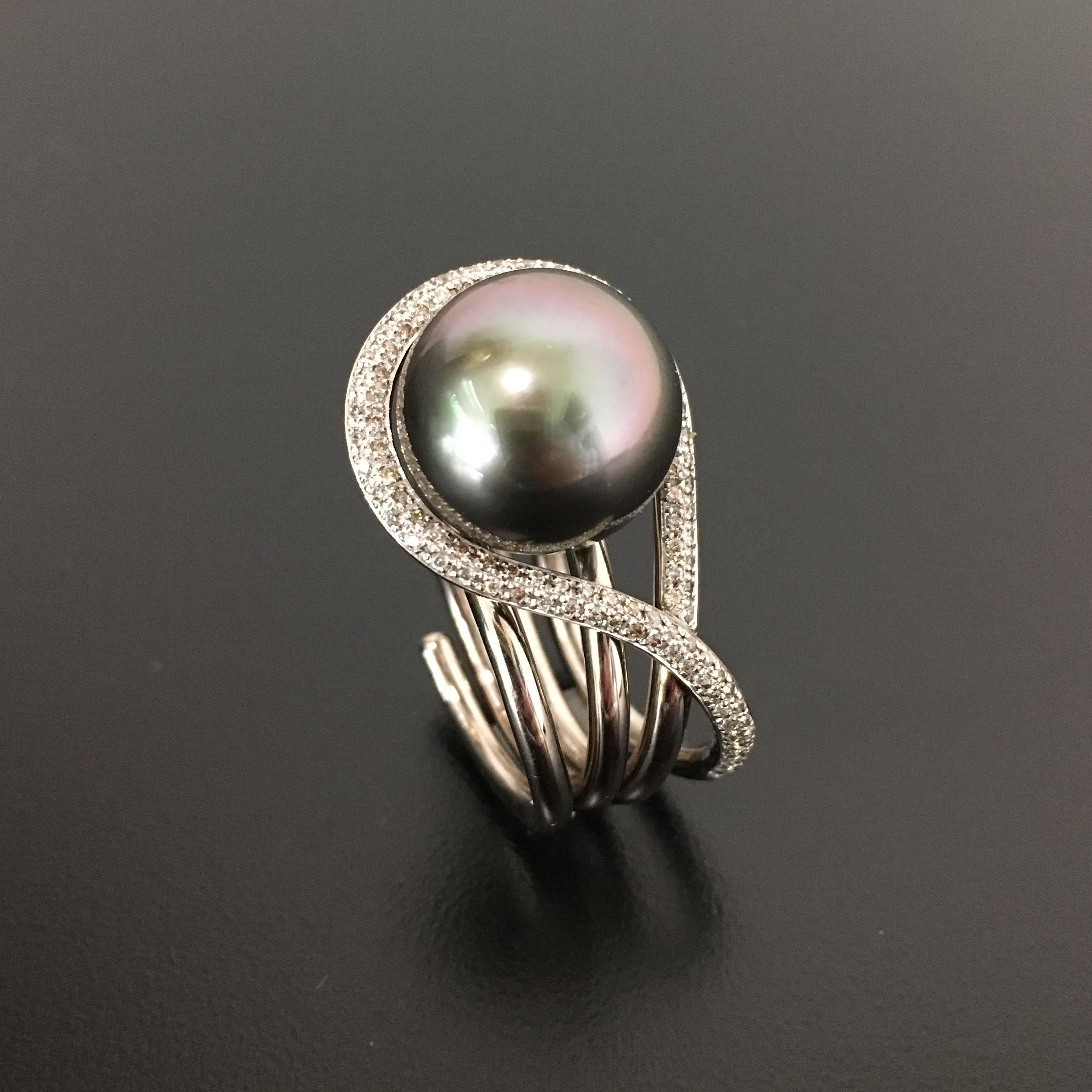 Smooth, curvy, big look but not bulky
A very elegant Ring with a real big Tahitian Culture Pearl, greyish color with pinkish
tone
18 Karat Whitegold with 106 fine diamonds in top top light brown color / si, 0,53 ct.