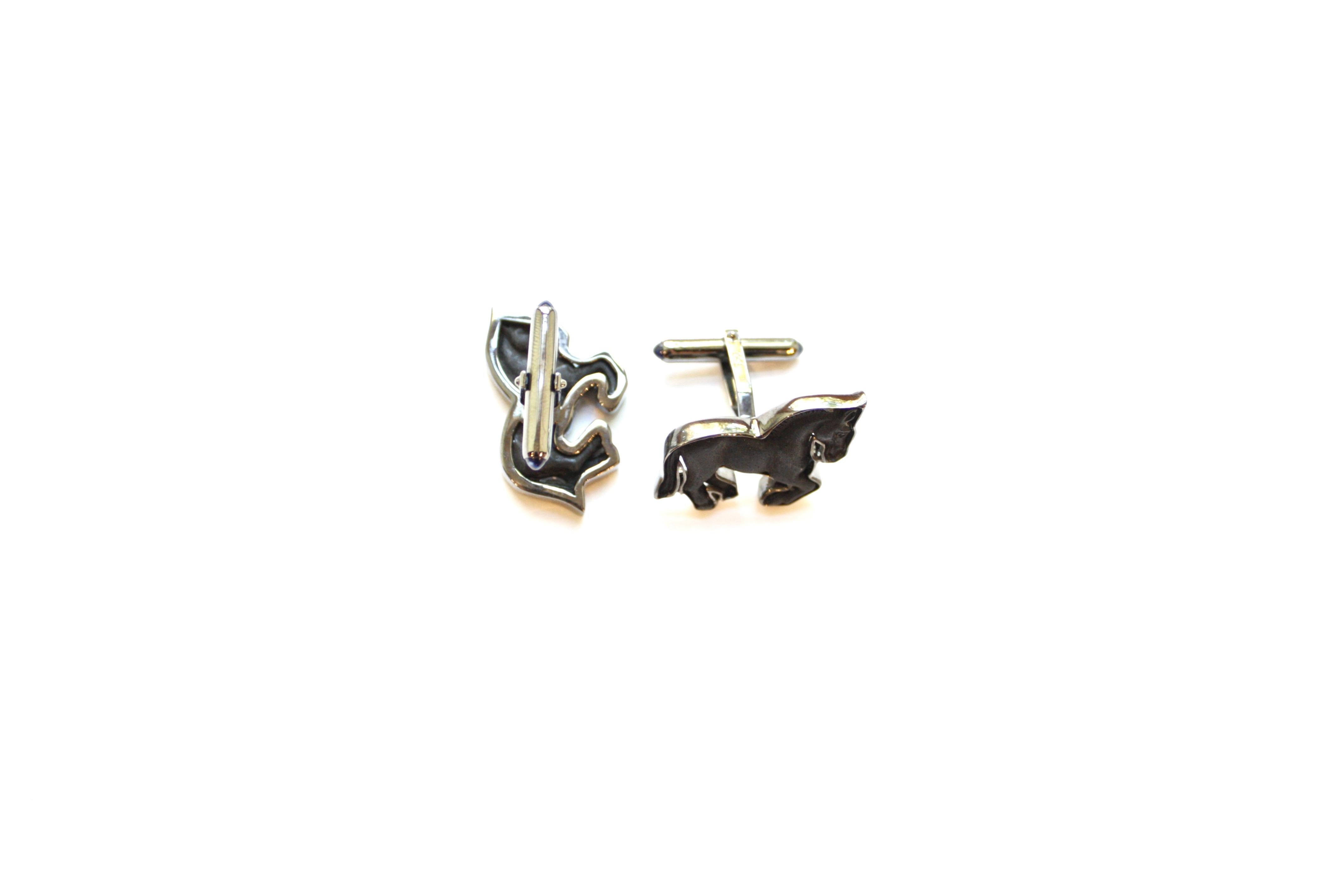 Horse Cufflinks
A pair of eighteen-karat white gold cufflinks, each set with a hand-carved ebony horse, mid gallop.  Additionally, the cufflink backs are each tipped with a blue sapphire cabochon.
Blue Sapphire Total Weight – 0.35cts.
Wood Total