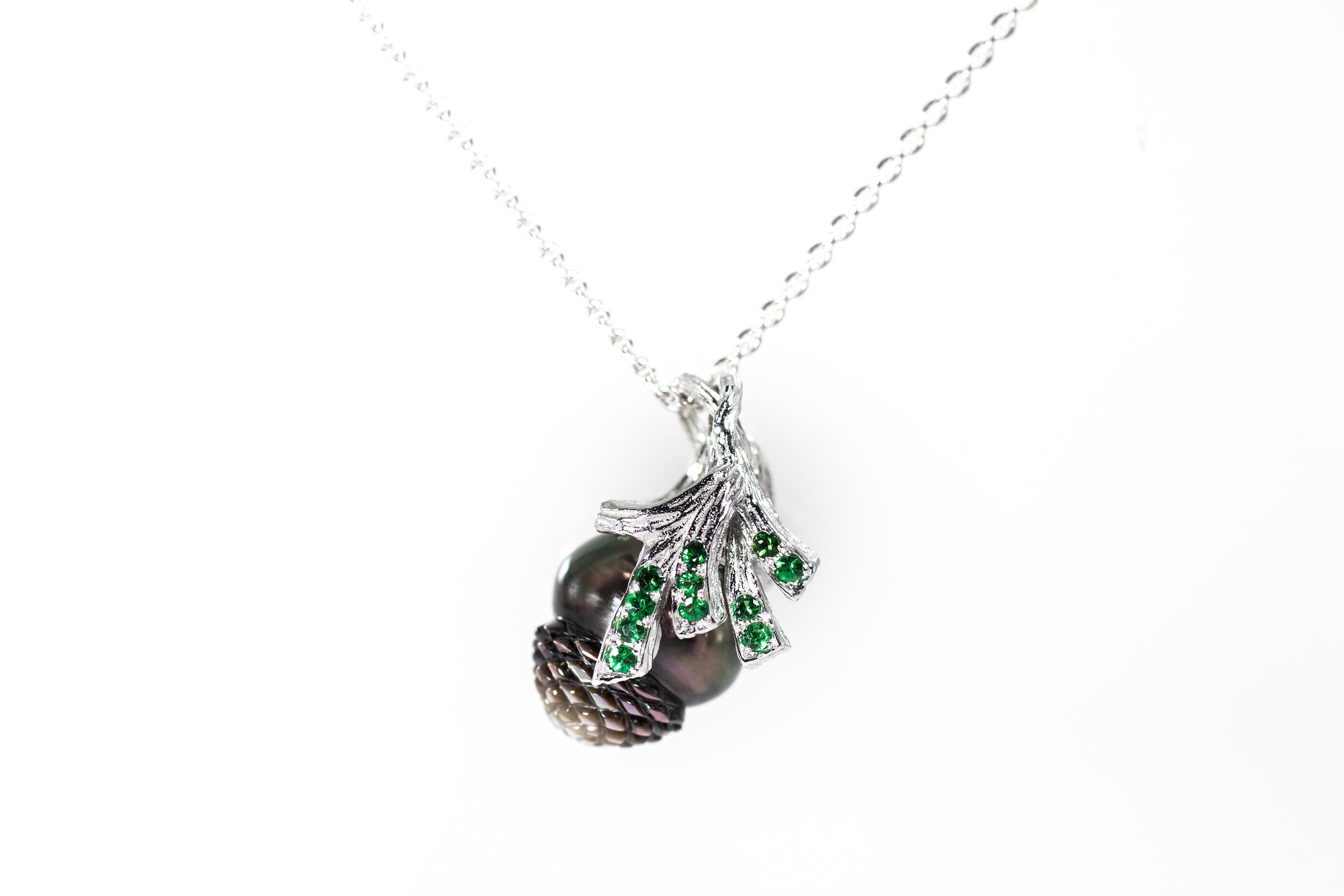 18K white gold pendant necklace set with handcarved pinecone shaped Tahitian pearl and tsavorites. 