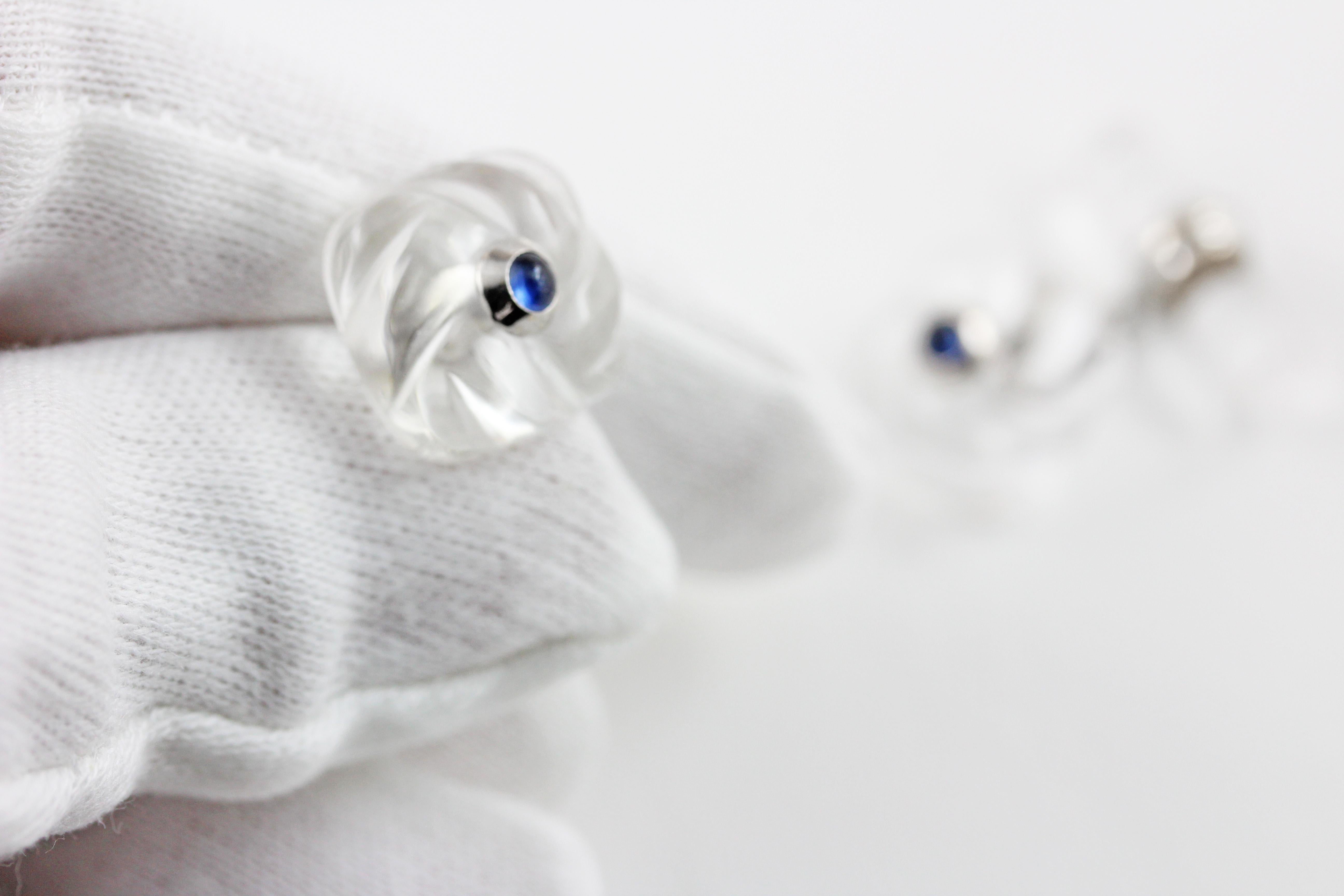 These classic cufflinks are made of rock crystal and feature a front face shaped as a square with a striking texture that mimics an interwoven fabric. The squares are adorned in the center with cabochon sapphires. The toggle is a simple cylinder