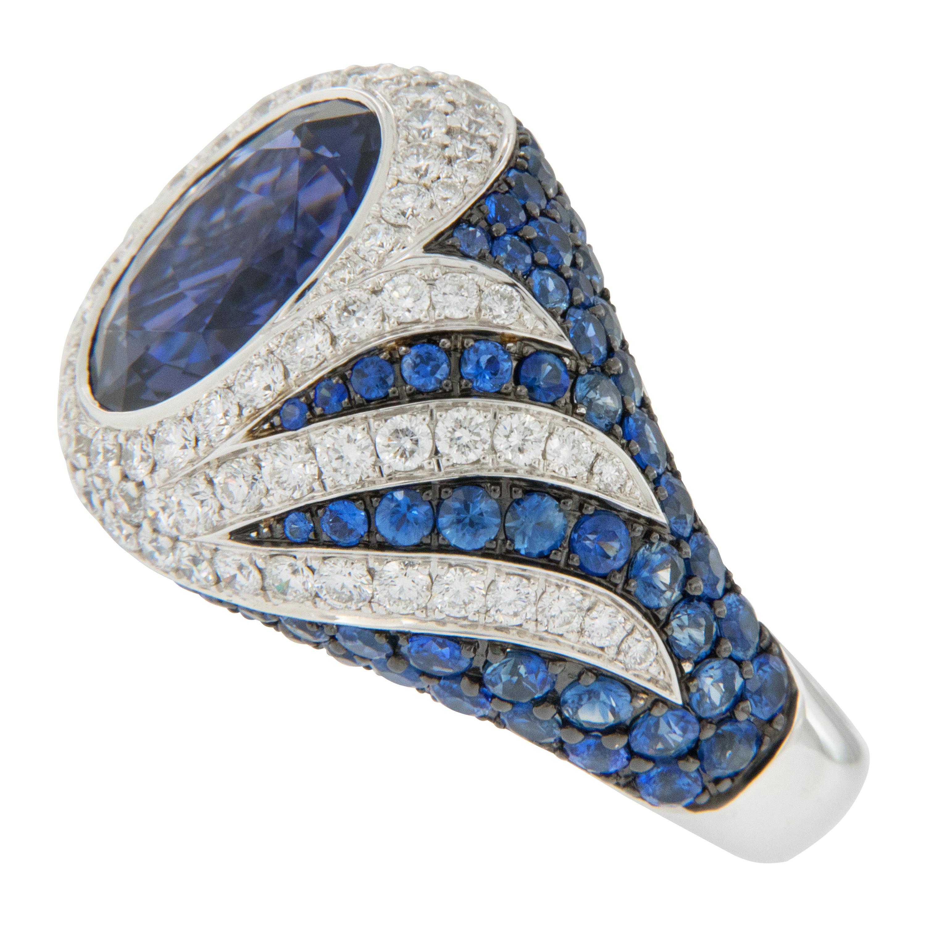 The name Iolite comes from the Greek word ios, meaning “violet.”  It is often cited as the twenty-first wedding anniversary gemstone. Crafted in 18 karat white gold with a swirl design, this ring features an oval fine Iolite accented with 1.44 Cttw