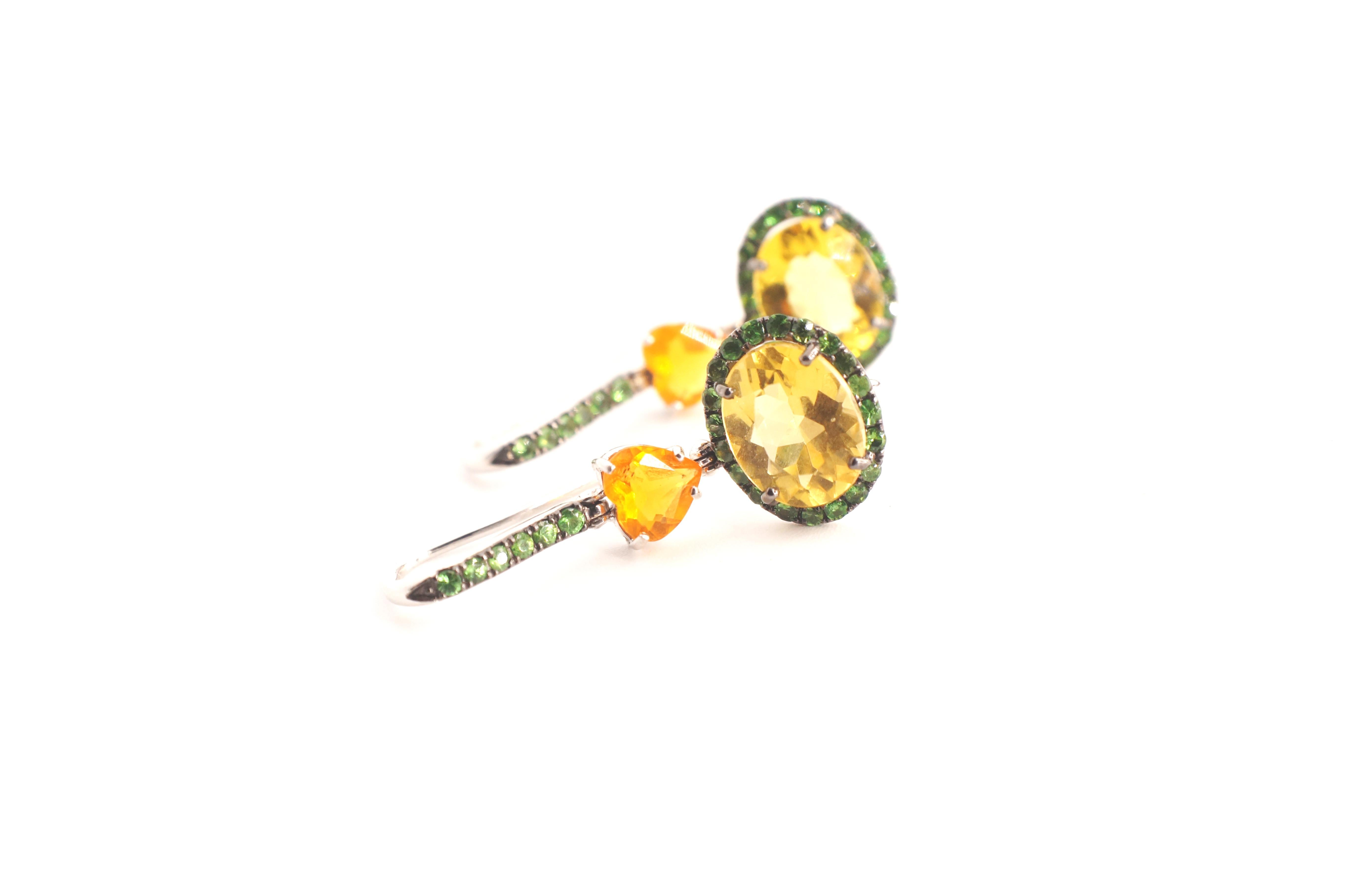 Freena Eardrops
A pair of convertible eardrops set in eighteen-karat white gold.  Each eardrop begins with a tsavorite garnet-encrusted earwire, suspending a heart shaped fire opal and a yellow beryl surrounded entirely by tsavorite garnets.  The