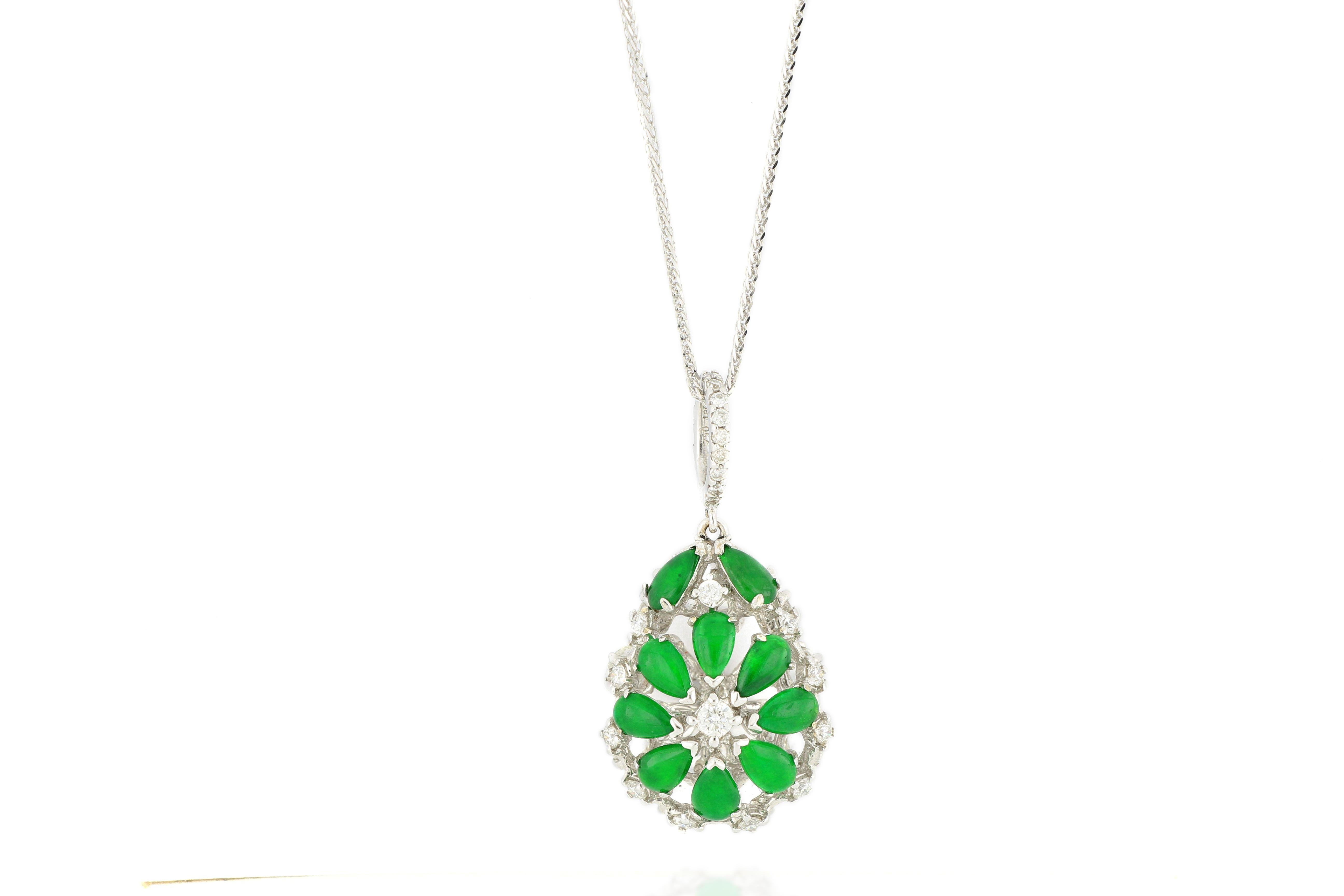 This is a very beautiful and unique 2-sided pendant, composed of 10 pieces of pear-shaped intense emerald green jadeite cabochon of very good translucency on one side, decorated with round brilliant-cut and rose-cut diamonds on both sides, total