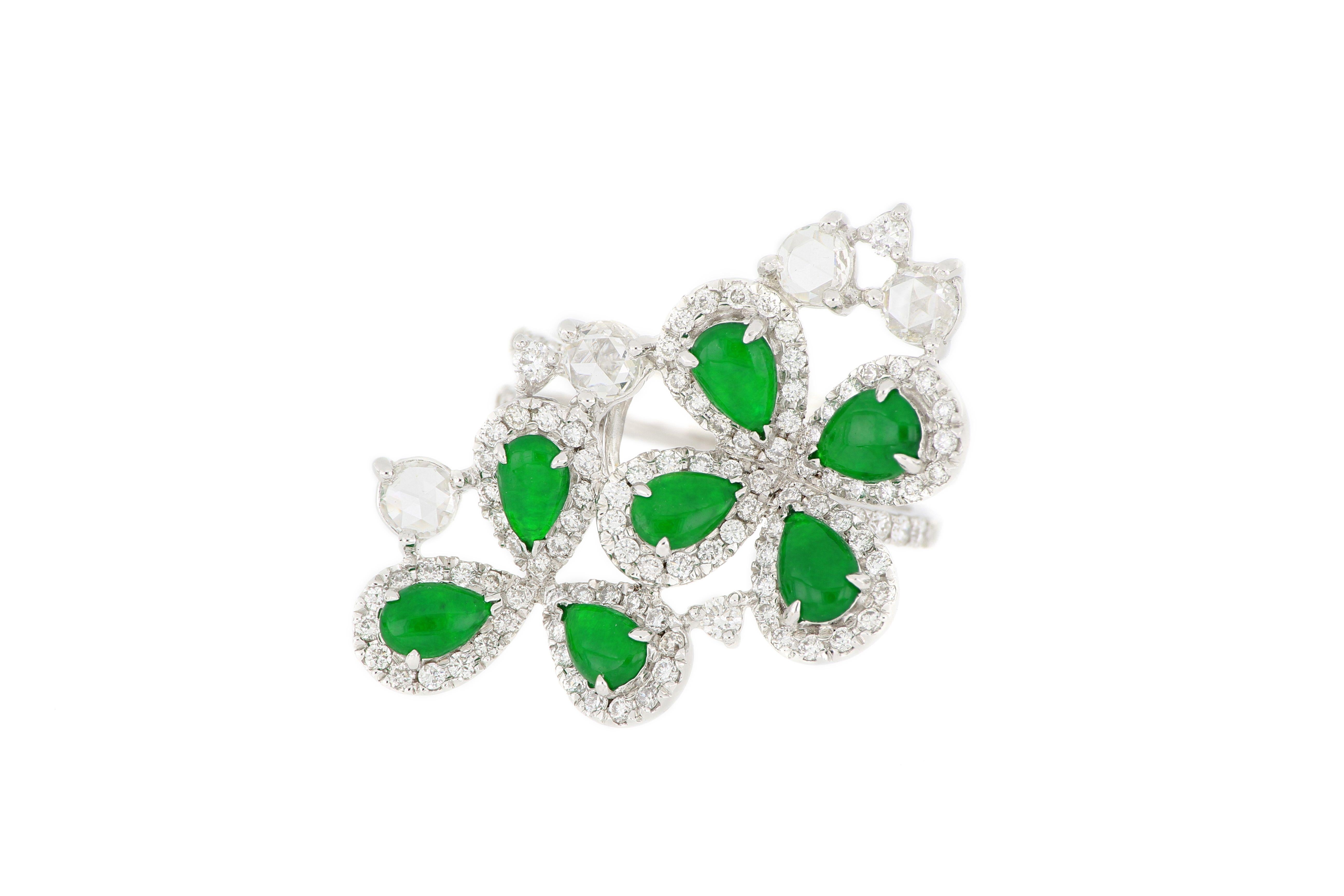 18 Karat White Gold Jadeite and Diamond Ring. The ring consists of 7 pieces of pear-shaped natural imperial Jadeite with very good translucency and vivid bright green colour,  arranged in a floral pattern, decorated with 4 rose-cut diamonds and