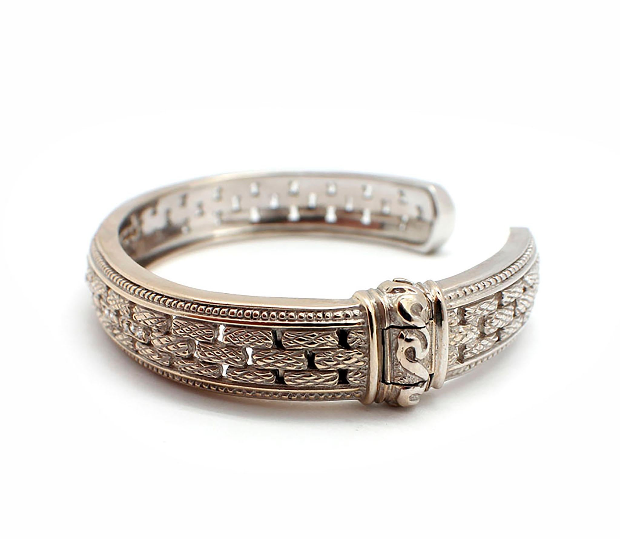 This rich Judith Ripka bangle bracelet is made of 18k white gold with a side hinge for an easy fit! The bracelet features 21 round diamond melee in sets of three down the center of the 11mm wide cuff bangle bracelet for a total diamond weight of