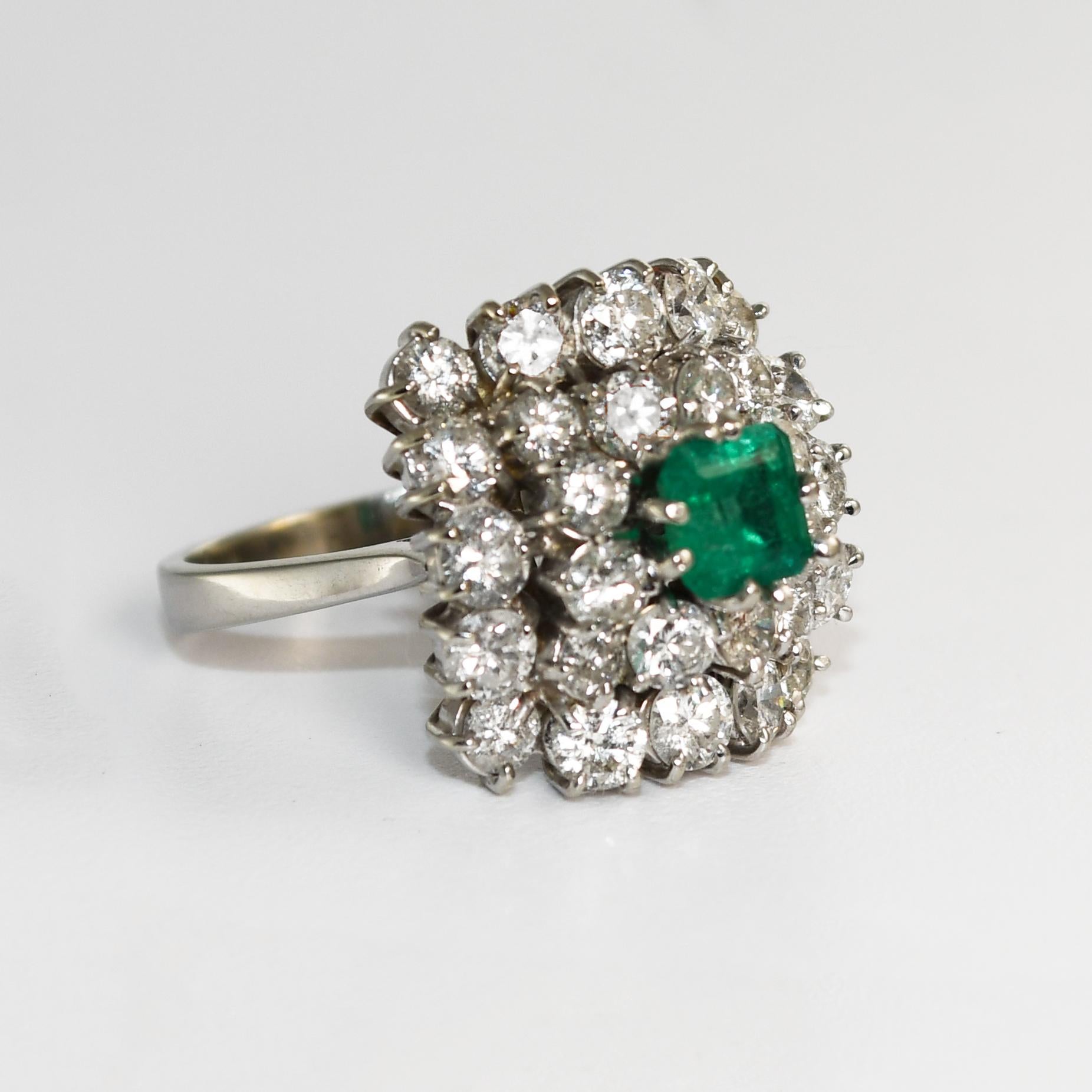 18k White Gold Diamond and Colombian Emerald Ring.
The center stone is a 5x5mm Colombian emerald with an approximate weight of 0.75 carats.
The emerald is surrounded by 28 round brilliant diamonds with a total weight of 2.50ct and SI1 clarity with I