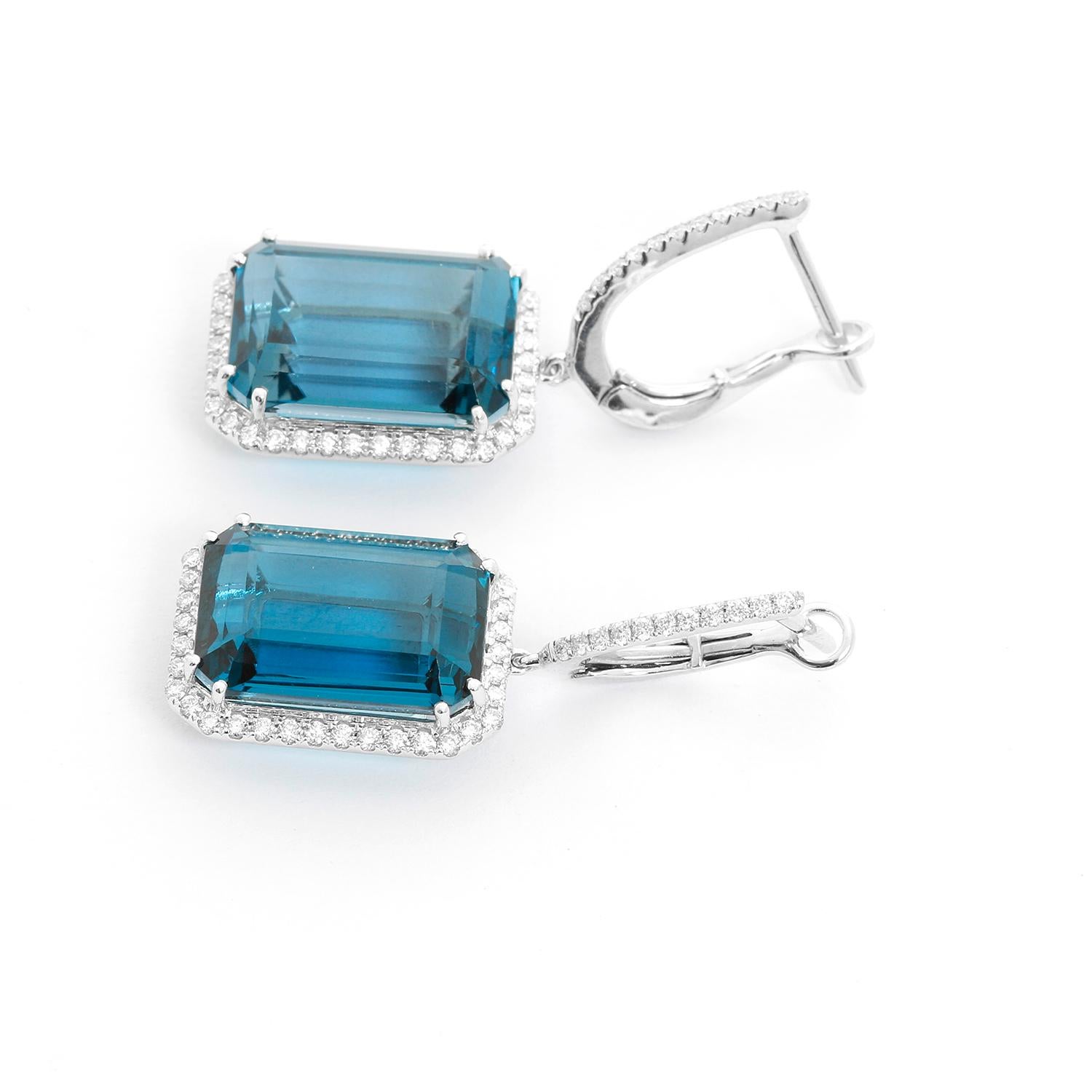 18K White Gold London Blue Topaz &  Diamond Earrings - 18K White Gold dangling earrings featuring an Emerald cut London Blue Topaz, weighing 21.49 cts. Surrounded by diamonds weighing .60cts.  Total measure 1/2 x  3/4 inches. Total weight 9 grams.