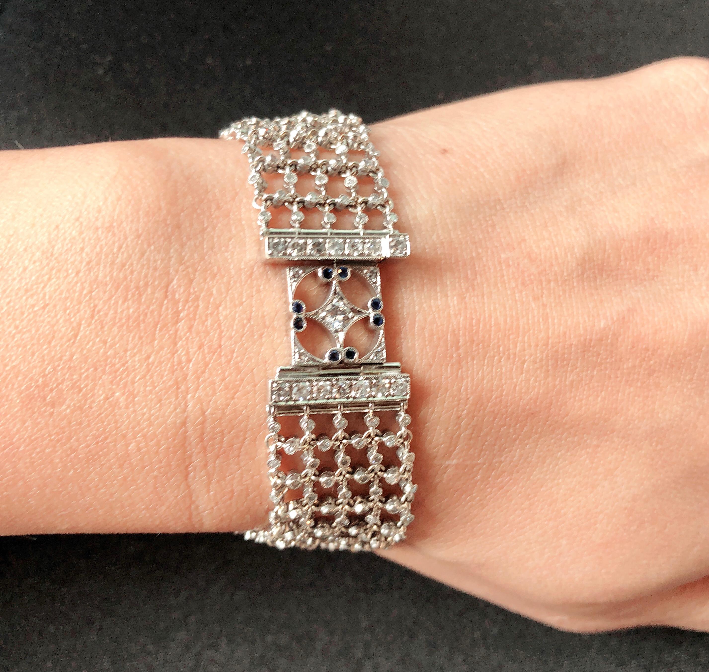 Bracciale in oro bianco 18 carati con zaffiri e diamanti. La maglia centrale è incastonata con 72 pietre di zaffiro da 0,01 che si intrecciano con 19 diamanti rotondi da 0,07, affiancati da 14 diamanti da 0,01 carati. La maglia centrale è dotata di