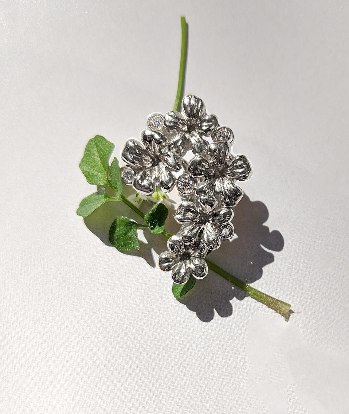 Diese Pflaumenblüten-Brosche ist aus 18 Karat Weißgold gefertigt. Er verfügt über 5 runde Diamanten und einen abnehmbaren natürlichen Smaragdtropfen (3,96 Karat, 13,5x7,5 mm), der abgenommen werden kann. Diese Schmuckkollektion wurde in der Vogue UA