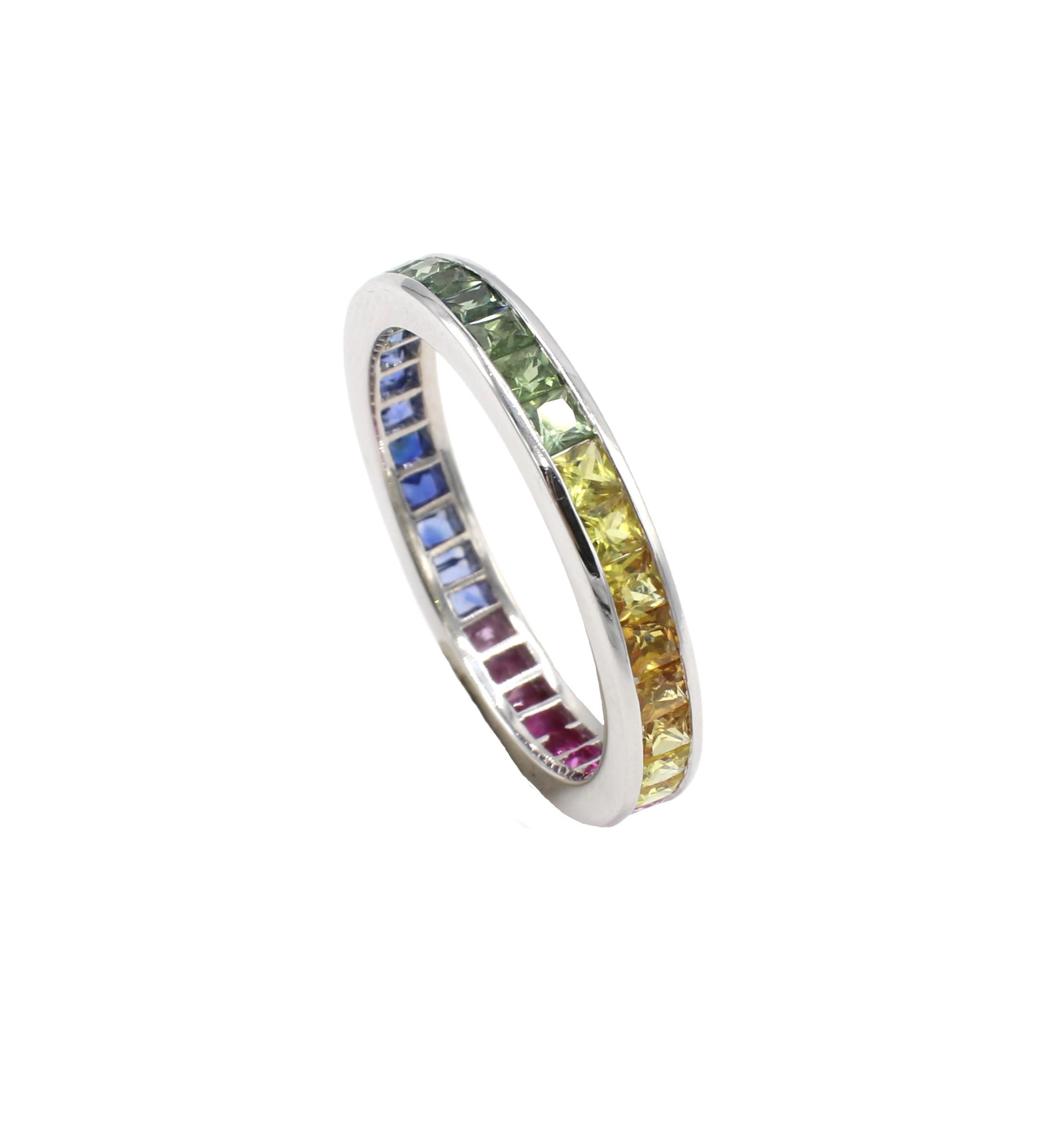 18 Karat White Gold Multi-Color Rainbow Sapphire Channel Set Eternity Band Ring 
Metal: 18k white gold
Weight: 3.72 grams
Size: 9 (US)
Width: 3.5mm
Sapphires: Multi-colored (pink, blue, yellow, green) sapphires

