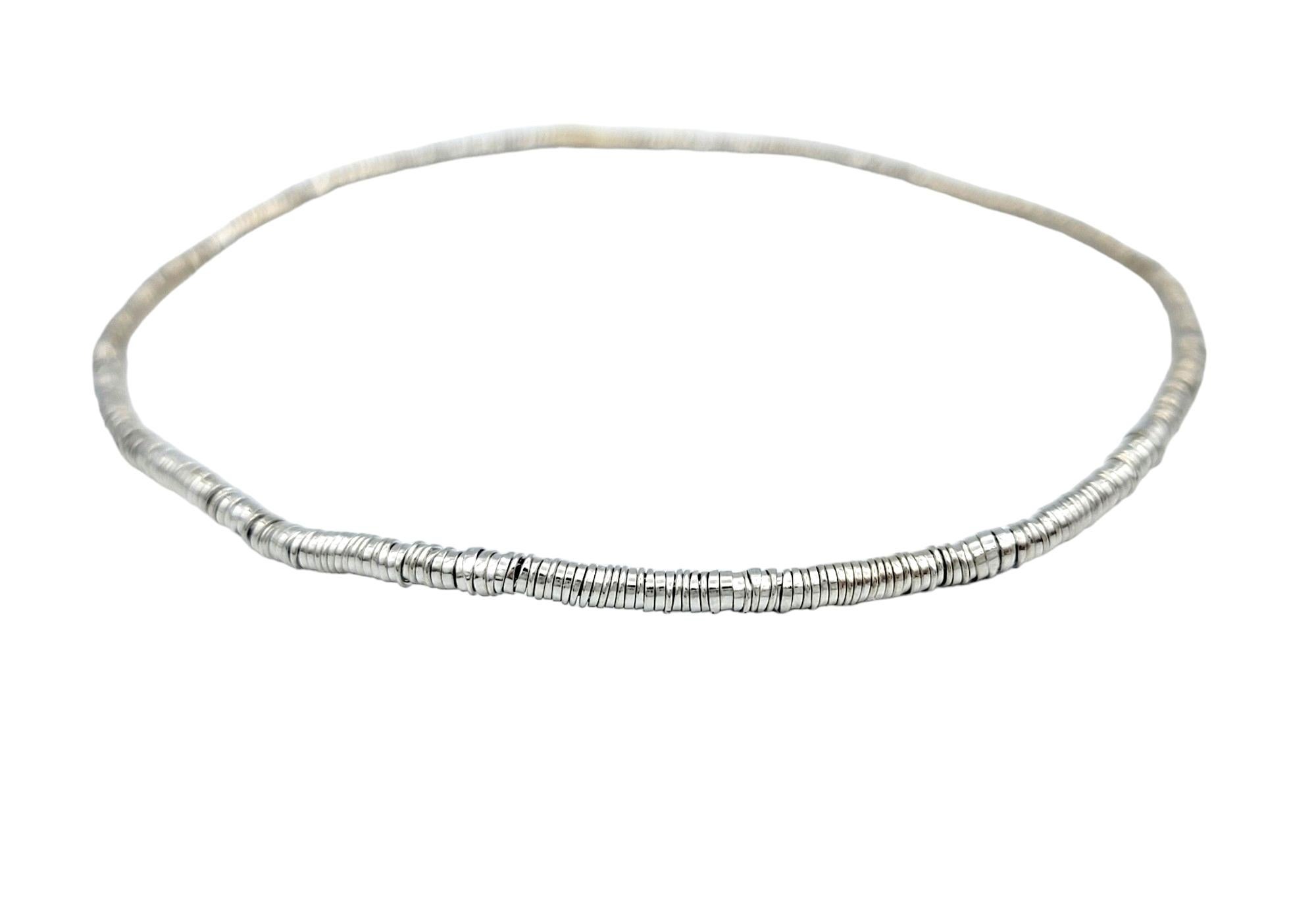 Eleva tu muñeca con elegancia atemporal llevando nuestra pulsera flexible de discos apilados de oro blanco de 18 quilates. Elaborada a la perfección, esta exquisita pieza presenta un delicado diseño, con diminutos discos apilados que simbolizan el
