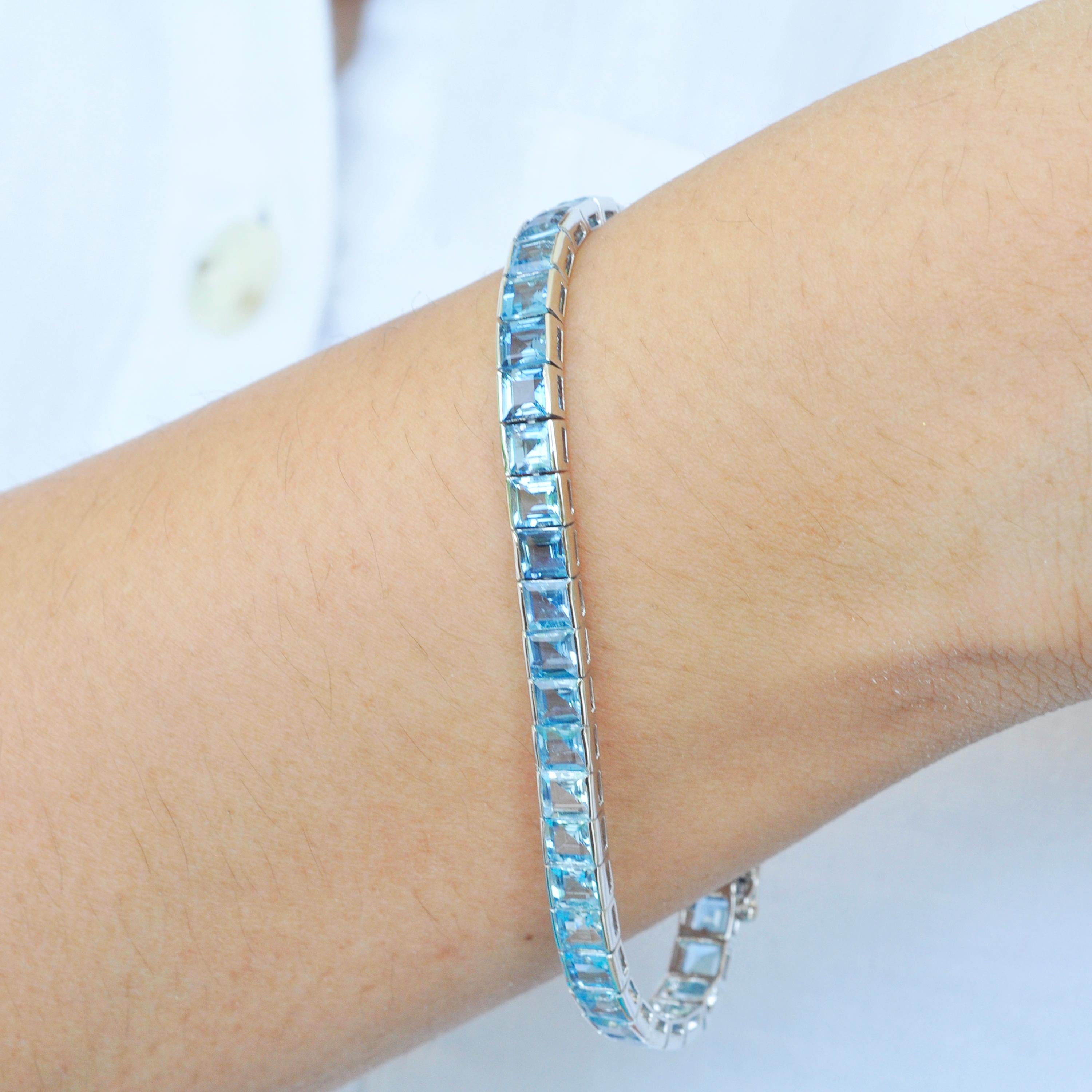18 karat white gold natural gradient aquamarine square tennis line bracelet.

This masterful royal aquamarine tennis bracelet is superb. Lustrous 4mm aquamarines are selected for perfect hue, lustre, color and clarity and carefully aligned from dark
