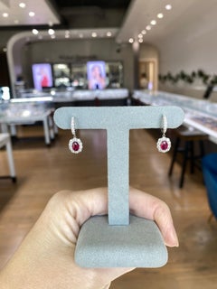 Boucles d'oreilles pendantes en or blanc 18 carats ornées de rubis ovales naturels et de diamants.