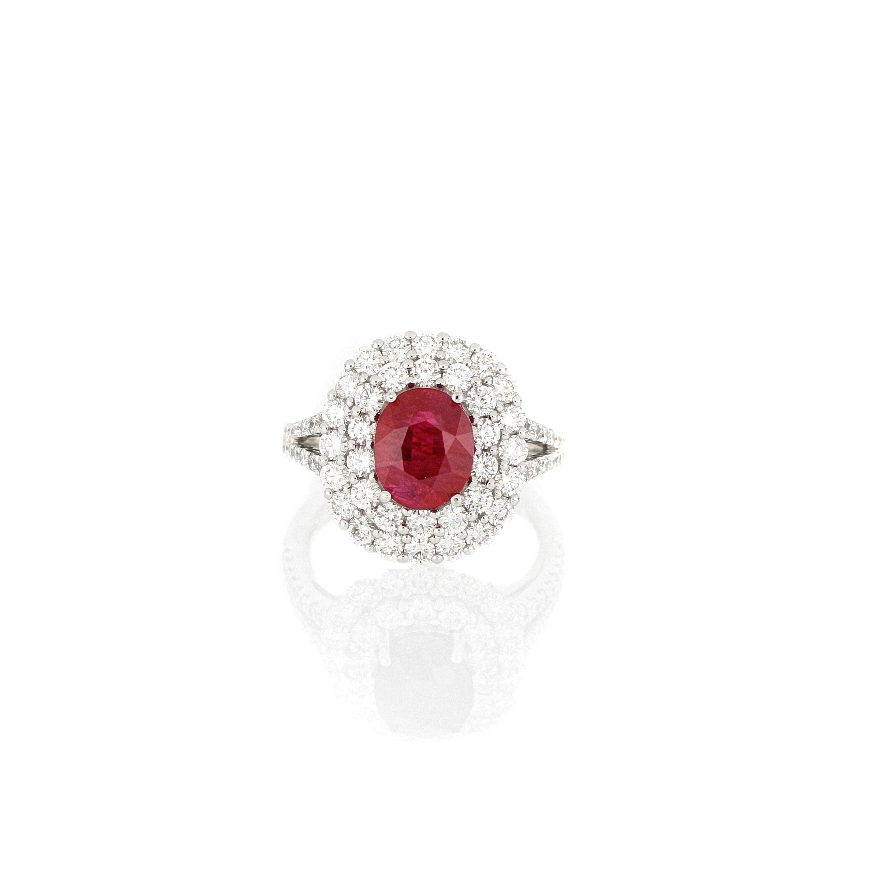 A fabulous natural ruby and diamond ring, A pigeon’s blood colour oval brilliant-cut ruby weighing 2.99cts, sourced in Burma, surrounded by round brilliant-cut diamonds extending to the shoulders, totaling 1.64cts , mounted in 18 karat white