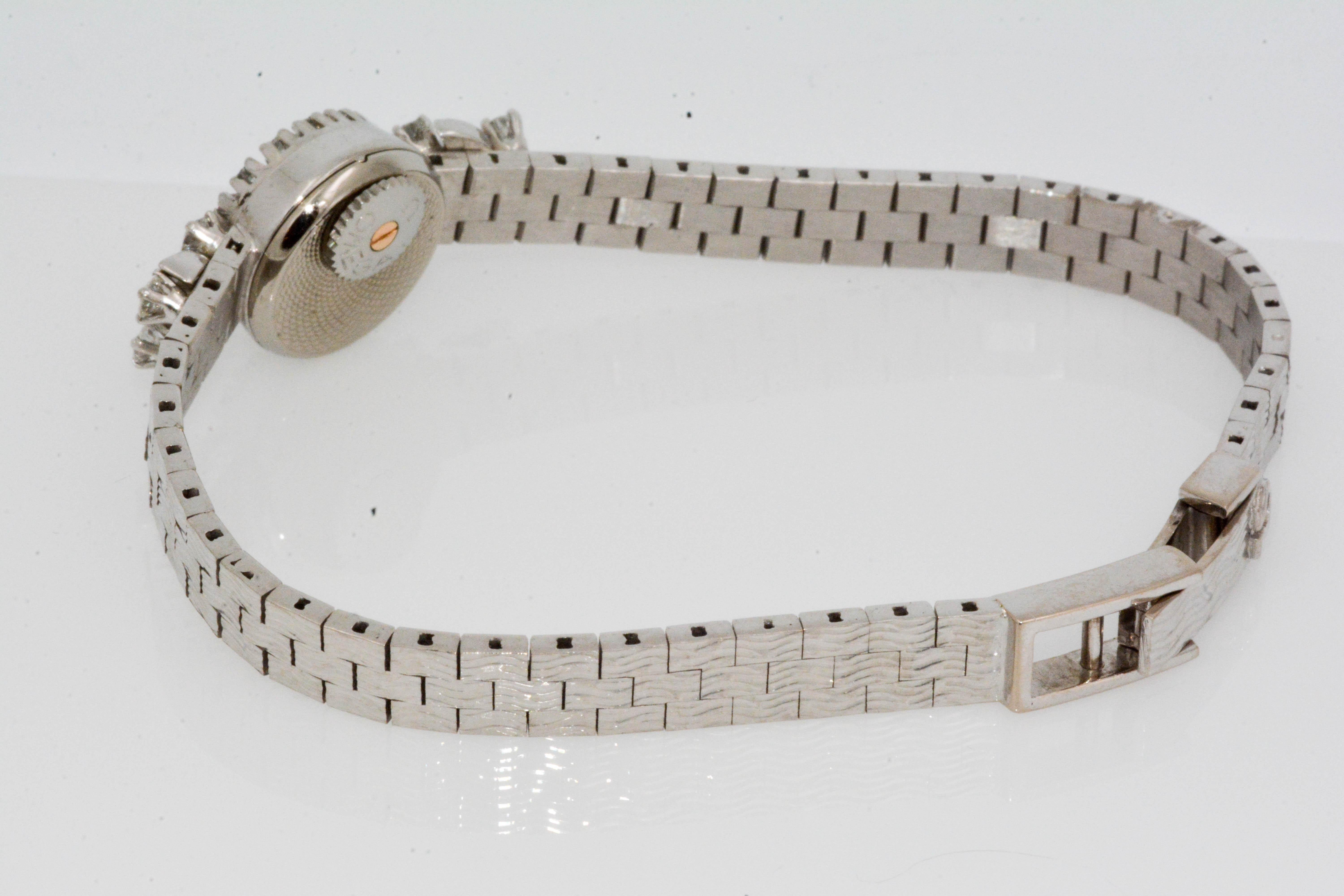 Circa 1960's 18 Karat white gold ladies Omega wristwatch. This stunning little beauty has 0.40 carat total weight round brilliant cut diamonds surrounding the bezel and at the top of the bracelet. Slim and shiny 18 karat gold bracelet. 