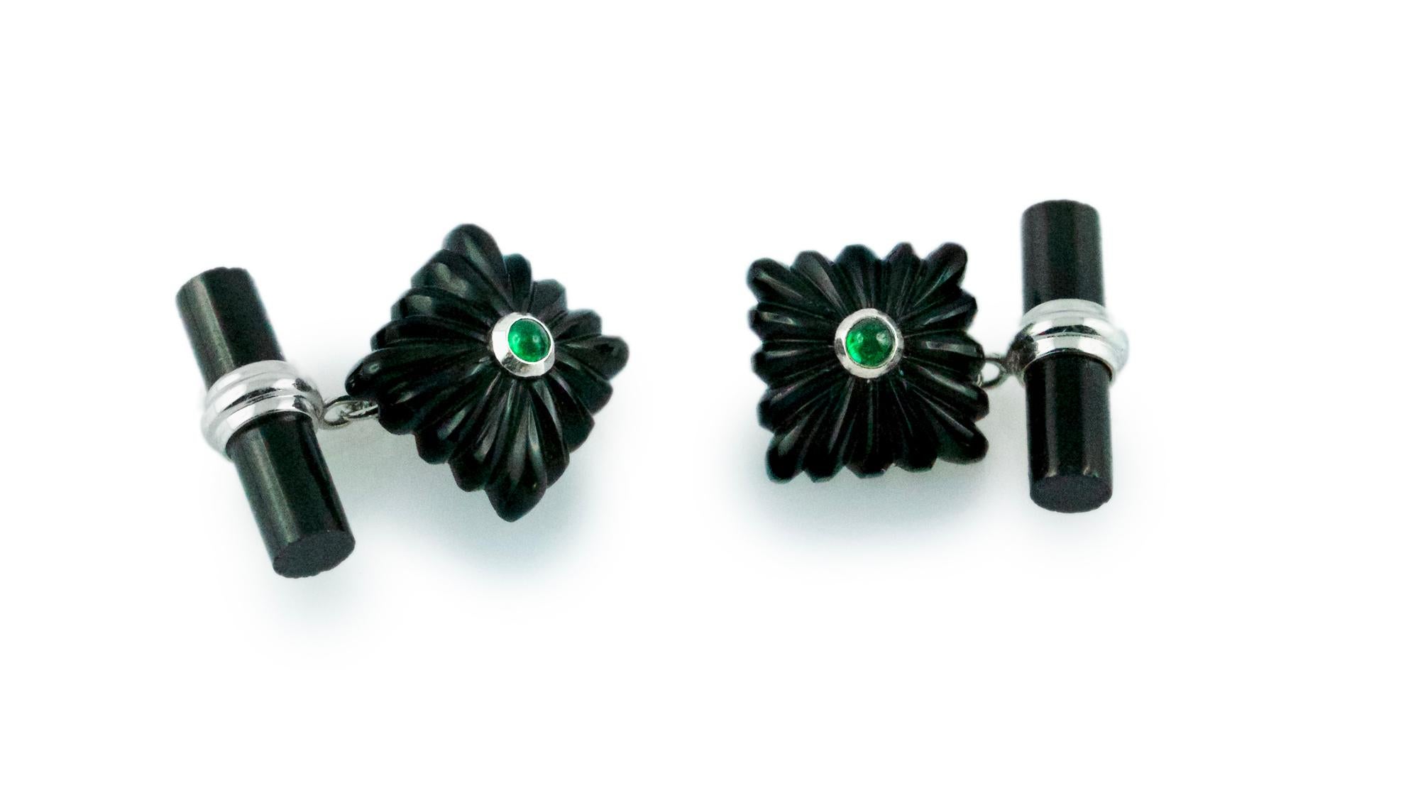 Striking and bold, this pair of cufflinks is made entirely in onyx. The toggle is a simple cylindrical bar, while the front face is shaped as a square with the classic “fesonato” texture. The center of the square is decorated with a cabochon emerald