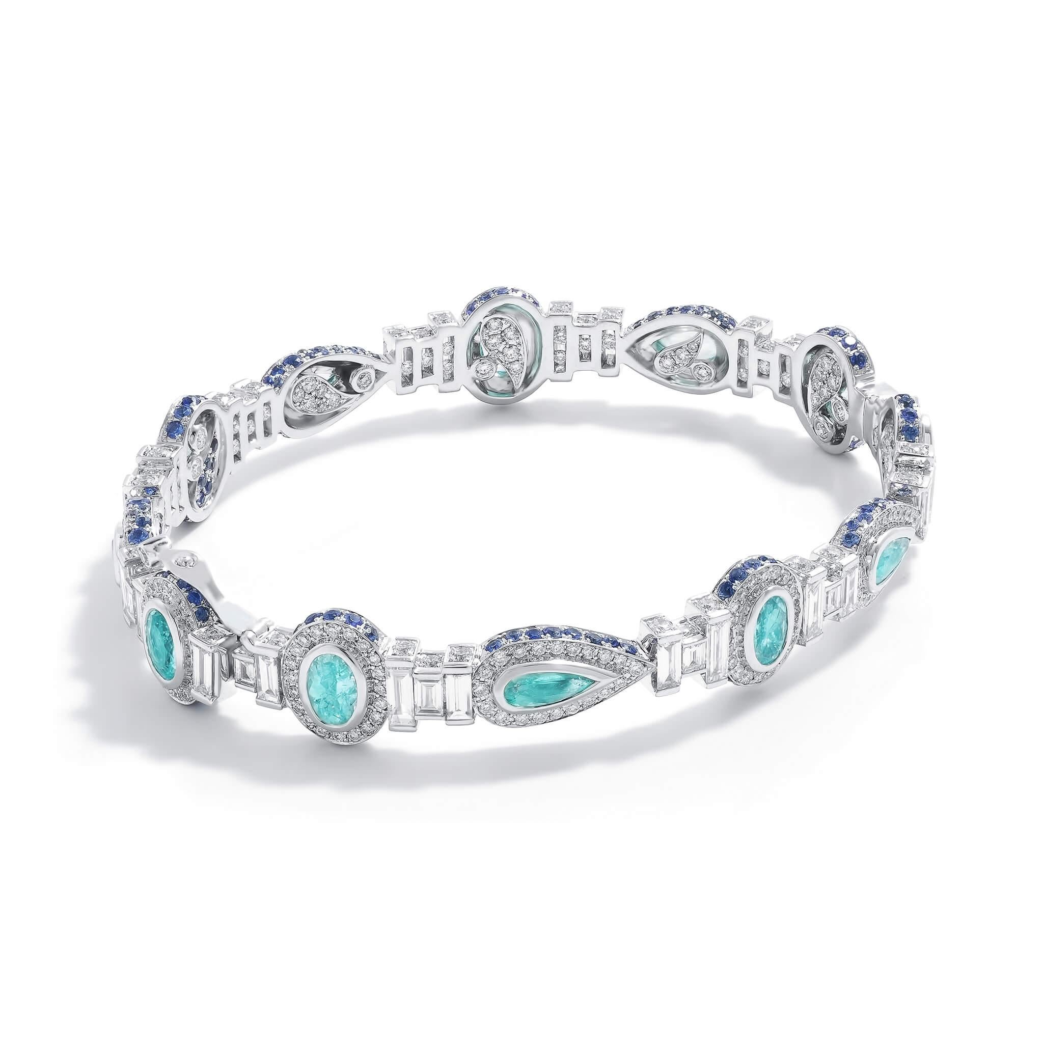 Divine 18 Karat White Gold Bracelet with finely detailed Paraiba weighing approximately 3.50 carats and Diamonds at 5.69 carats with charming Blue Sapphire weighing at 0.99 carats. This bracelet is every Paraiba admirer's dream. It is crafted