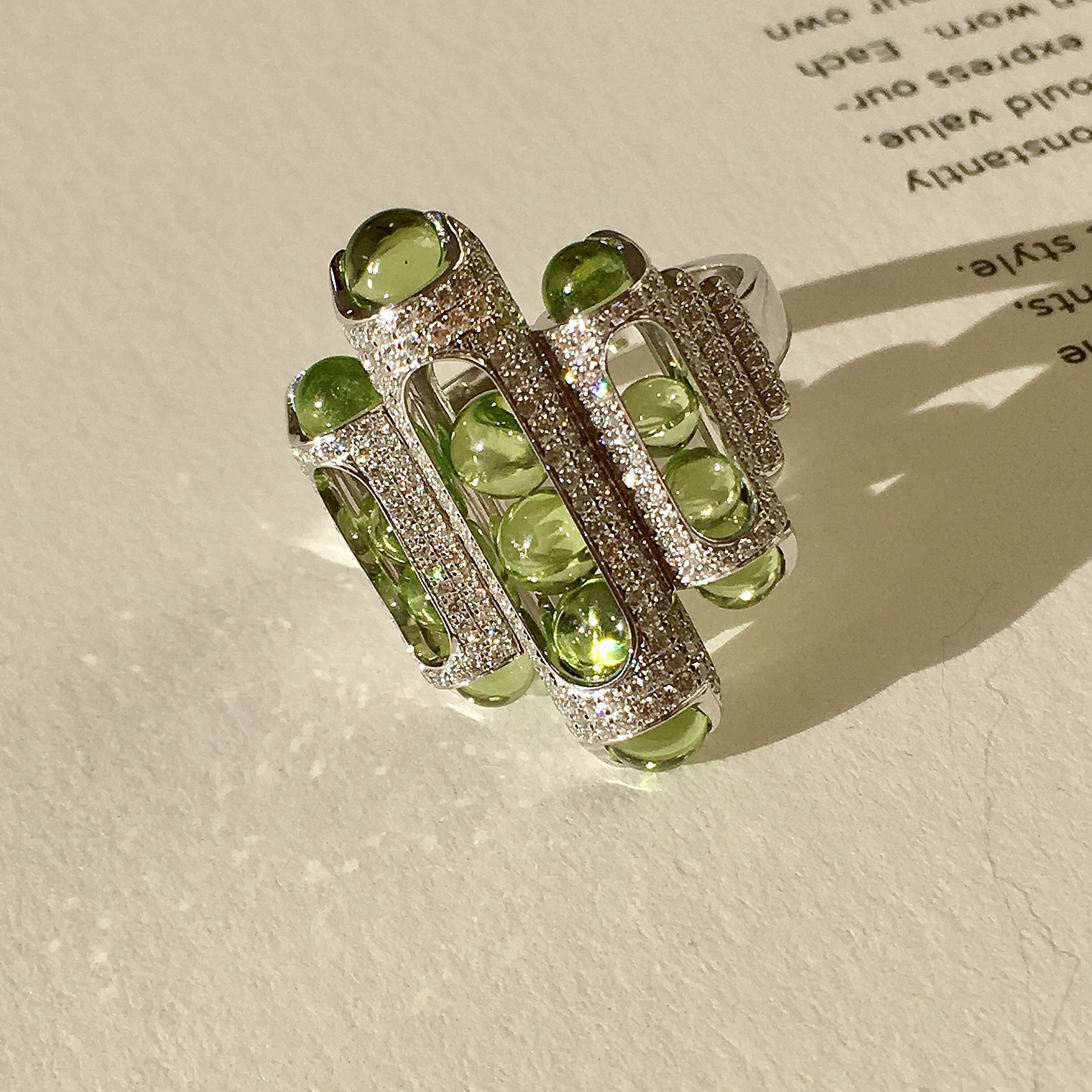 This unique Melody cocktail ring combines perfect hand carved Fuli peridot beads that roll within their 18 karat gold, pave diamond setting. Gold award winning Melody collection is a clever design solution.  Each piece incorporates a unique movement