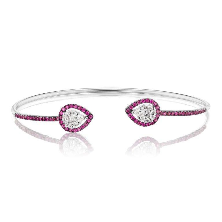 A vibrant hue of colors, this cuff bangle in 18K white gold is featured with rubies and diamonds. This bangle is made with 10 marquise diamonds and 70 pave rubies.

JEWELRY SPECIFICATION:
Approx. Metal Weight: 4.76 gram
Approx. Diamond Weight: 0.53