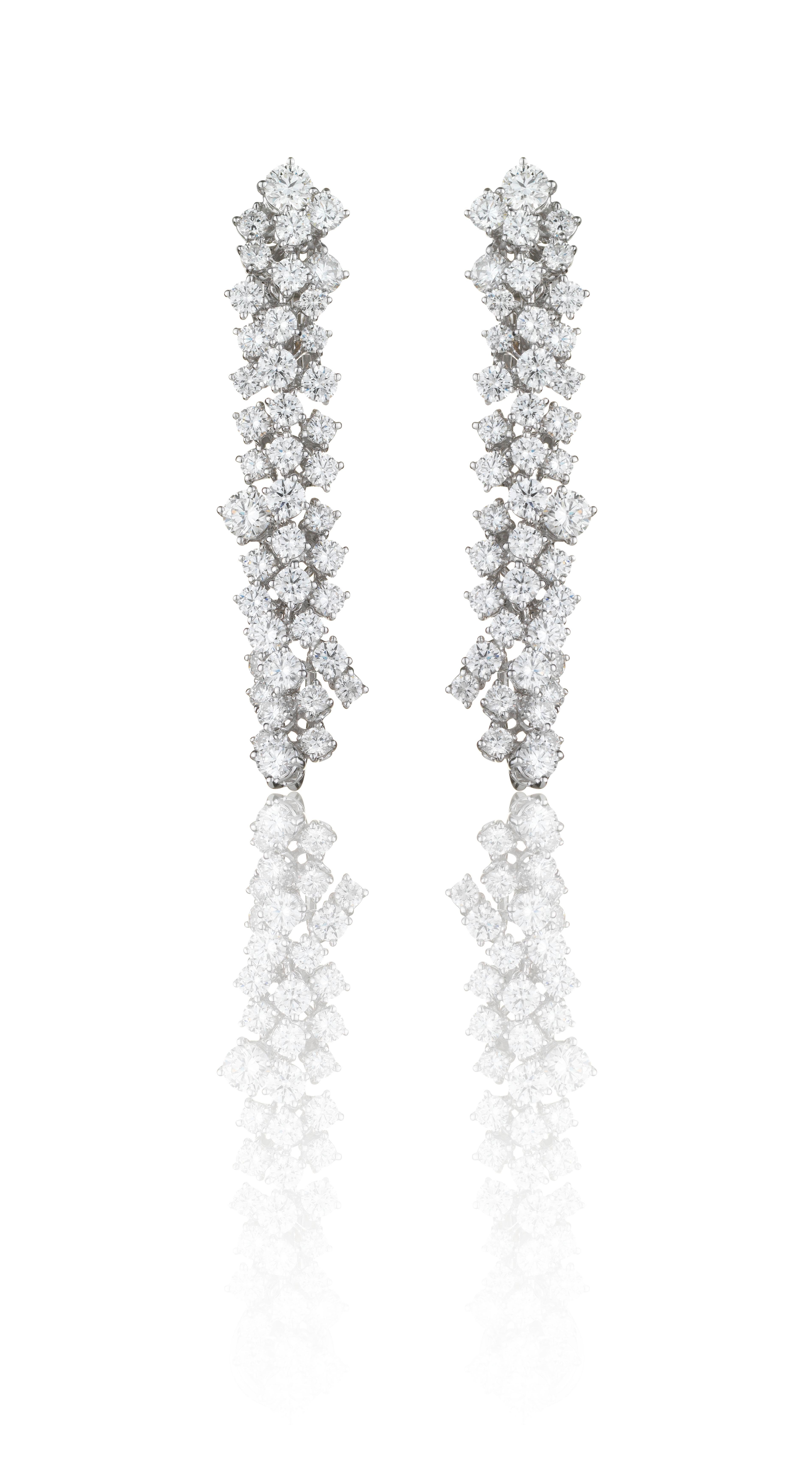 Cascading diamonds and pure white pearls create these breath-taking diamond and pearl drop earrings. An illuminating, flowing cluster of brilliant-cut white diamonds drop to hold a single, luminescent round South Sea pearl. The pearl is detachable
