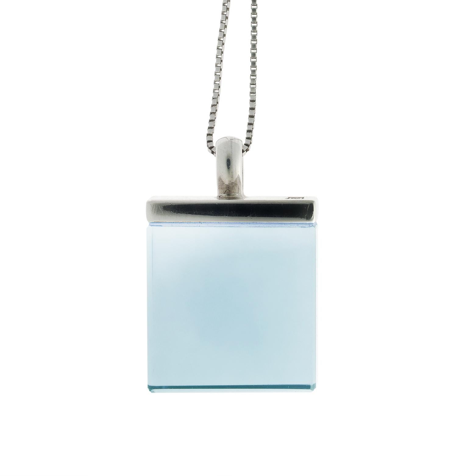 Voici une version révisée de votre texte, dont la grammaire et la fluidité ont été améliorées :

Ce collier pendentif de créateur de style Art déco présente un quartz bleu de 15x15x8 mm et est réalisé en or blanc 18 carats. Il appartient à la