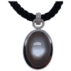 Pendentif en or blanc avec 1 pierre de lune noire et diamants.  