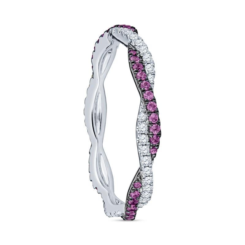 This infinity style eternity band features pink sapphires and diamonds that intertwine together and are set in 18 karat white gold. The ring is a size 6.5. Please contact us for alternate sizing. 
Measurements: Width approximately 2.50mm
