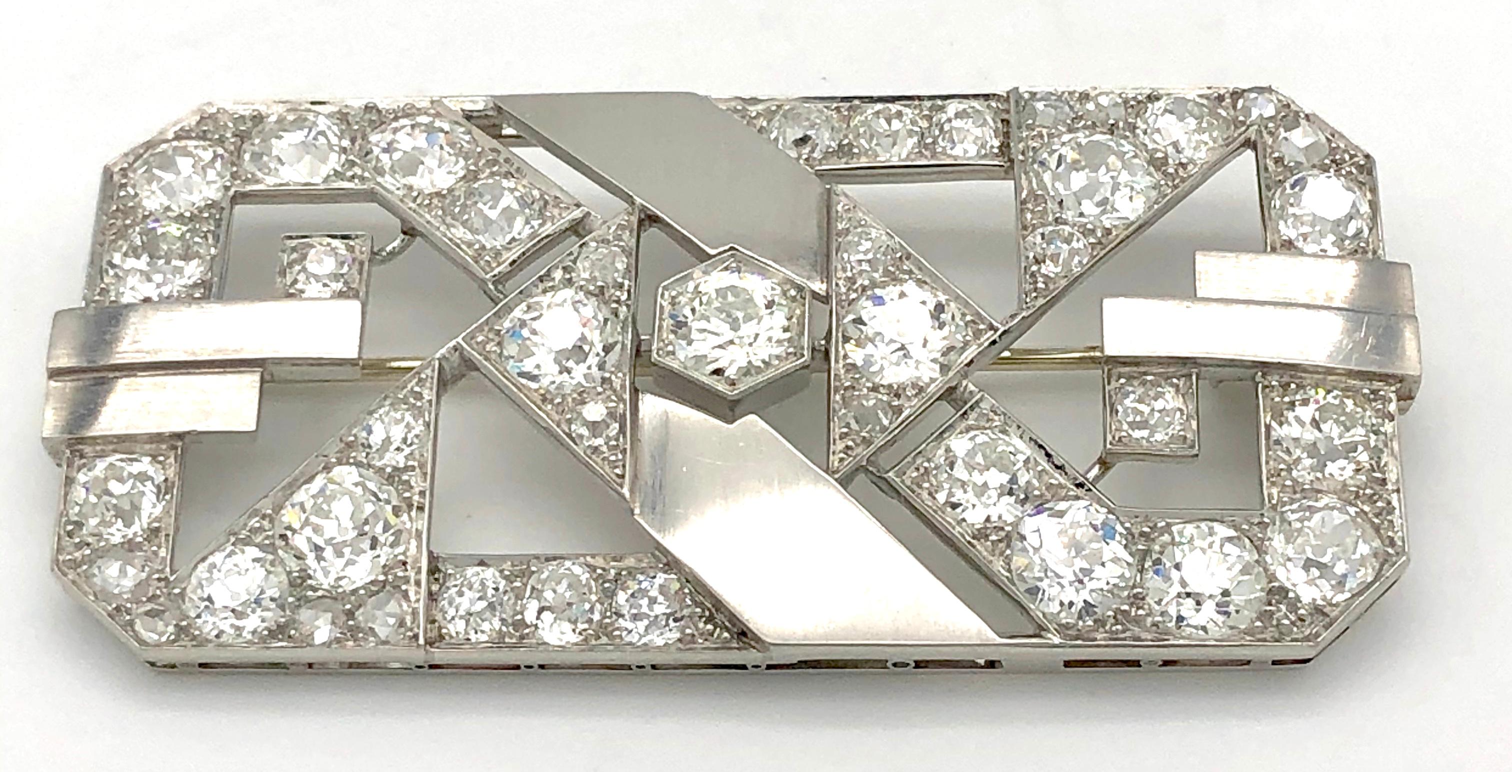 The design of this very elegant, diamond set platinum and white gold Art Deco brooch plays with the contrast  of the serenity of plain polished surfaces and the flamboyance of 41 sparkling diamonds with a total weight of 11 carats ca. 
This piece of