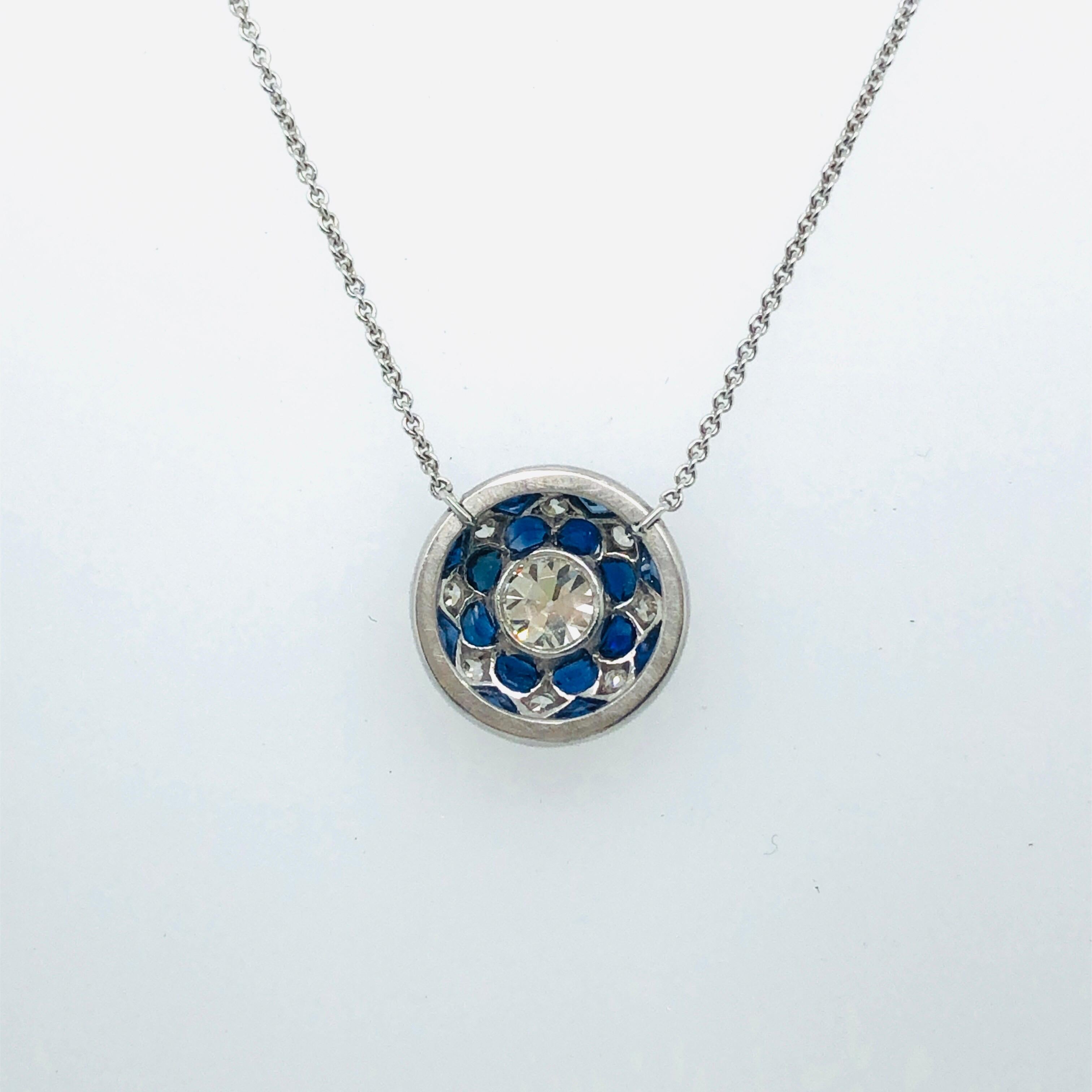 Adorable 18 karat white gold platinum old-cut diamonds and sapphires pendant necklace. 
The necklace is centered by an antique round platinum element set with an old round cut diamond of circa 0.4 carats ( M / vvs ) surrounded by small blue