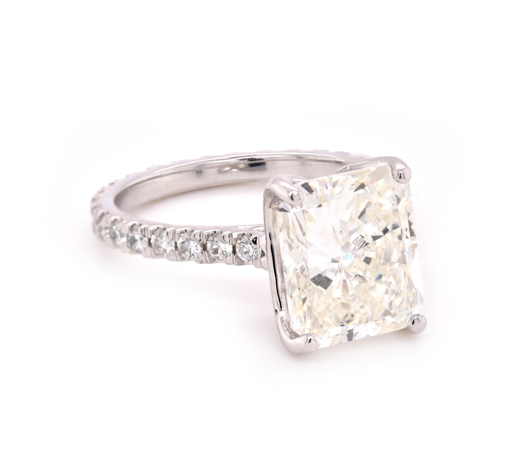 Material: 18k white gold
Center Diamond: 1 radiant cut = 4.41ct
Color: J
Clarity: VS2
GIA Cert#: 11048933
Diamonds: 29 Round brilliant cuts = 0.58cttw
Color: G
Clarity: VS
Ring Size: 7  (please allow up to 2 additional business days for sizing
