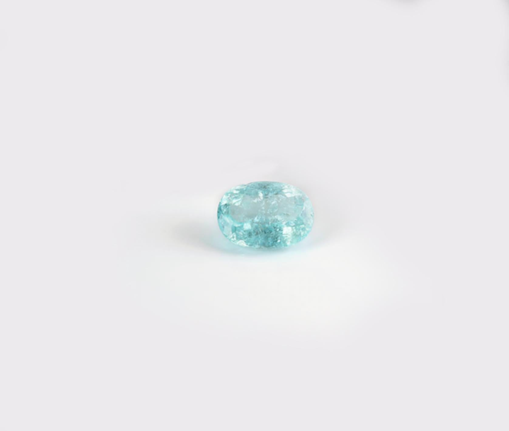 This 18 karat white gold ring features a 4.11 carat neon copper bearing Paraiba tourmaline (12x8.7mm) in an oval cut, with a very blue hue. The gem's impressive size draws attention to the fine jewelry craftsmanship, which includes delicate prongs