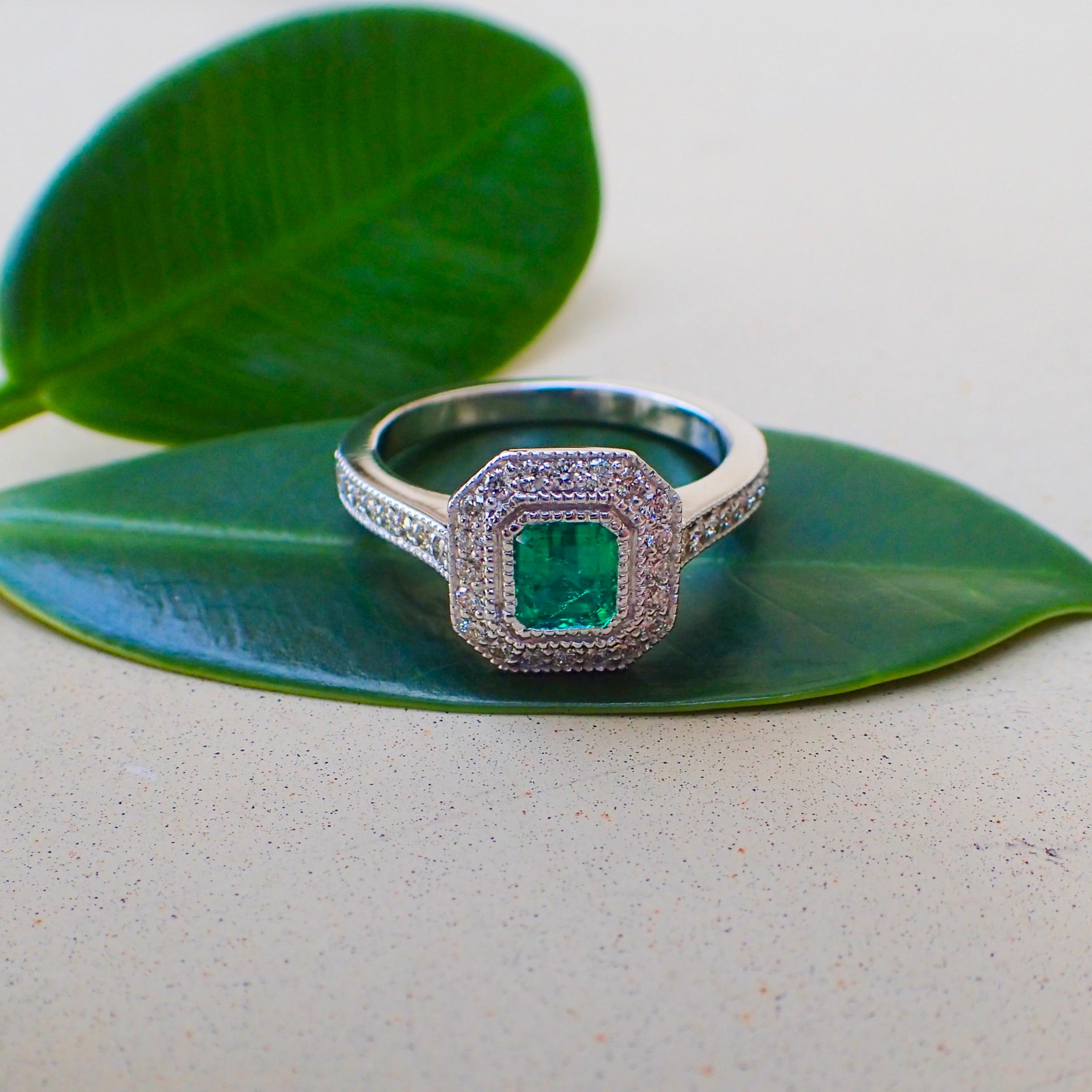 One (1) 18k white gold ring contains one (1) Emerald Cut emerald that measures 4.69mm x 5.13mm and weighs 0.518 carats with Clarity Grade SI3, and thirty-eight (38) Round Brilliant Cut diamonds surrounding the center and lining the shank that weigh