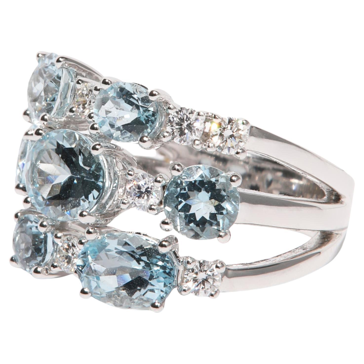 18 karat white gold ring is set with round and oval cut aquamarine a total of 3.89 carat of gemstones. Sparkly brilliant cut diamonds, a total of 0.60 carat, are set in between the lightblue soft tones, creating a wonderful festive ring for every