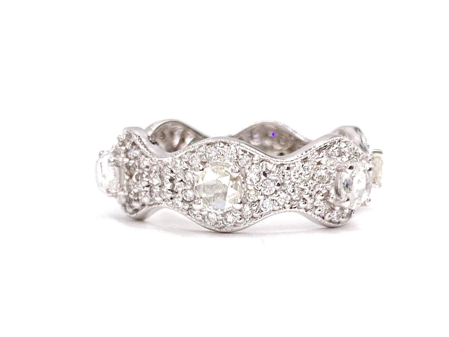 Designed by Barry Kronen. An 18 karat white gold curved eternity diamond ring featuring approximately .75 carats of round rose cut diamonds surrounded by approximately .65 carats of pave set round brilliant diamonds (1.40 diamond carat total