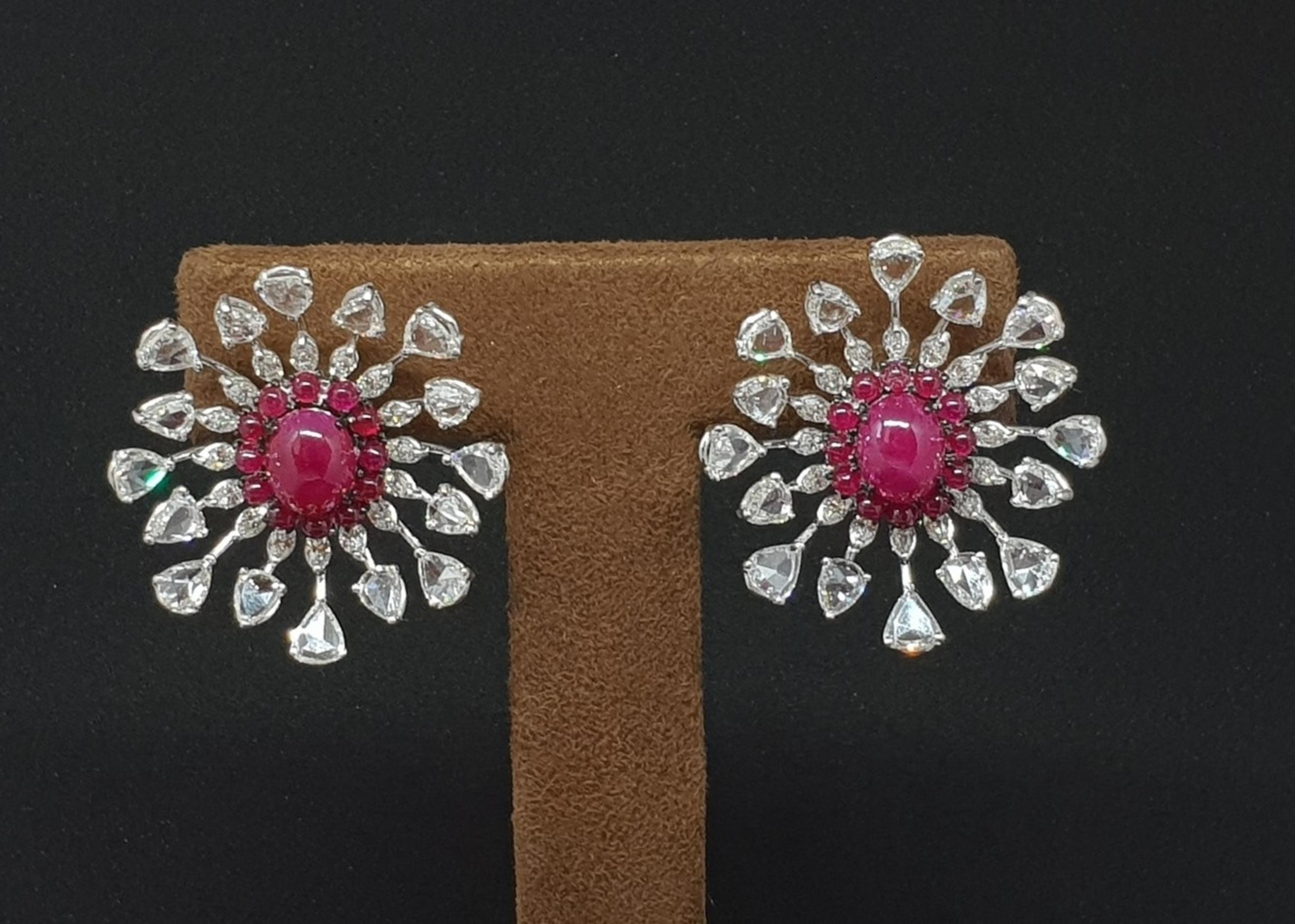 The rays of the sun always sends out a positive energy. Designed with the same spirit, the pear shape rose cut diamonds & brilliant cut marquise shape diamonds emit from the centre stone which is a ruby cabochon in these earrings.The placement of