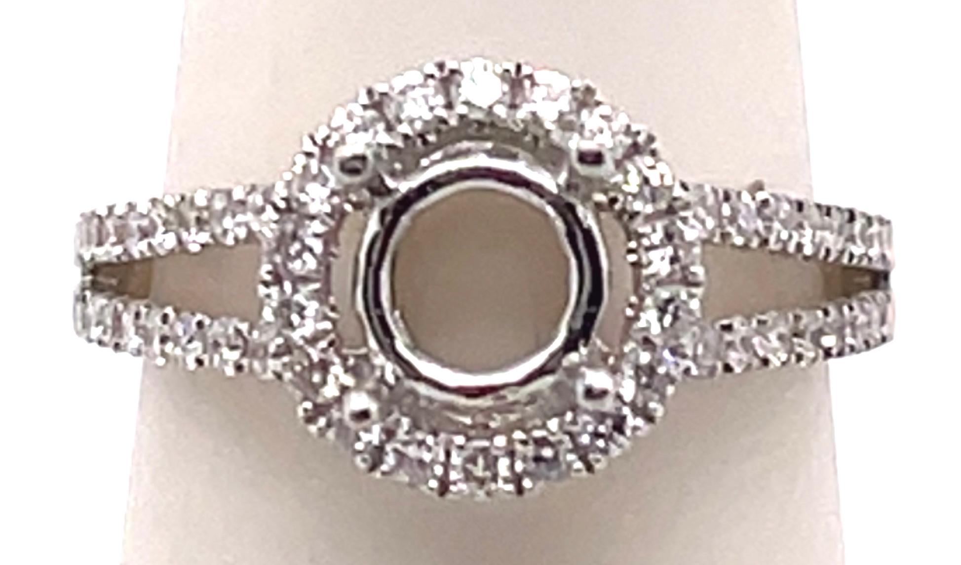 18 Karat White Gold round engagement ring setting with diamond halo and two row diamond band.
Size 6.5
0.71 total diamond weight.
3.72 grams total weight.
