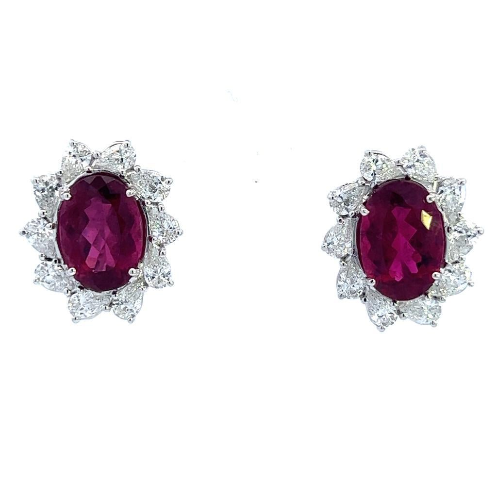Step into a world of unparalleled luxury with these exquisite 18 karat white gold earrings, adorned with a magnificent combination of rubellite and diamonds. The focal point of each earring is a breathtaking oval-cut rubellite gemstone, totaling an