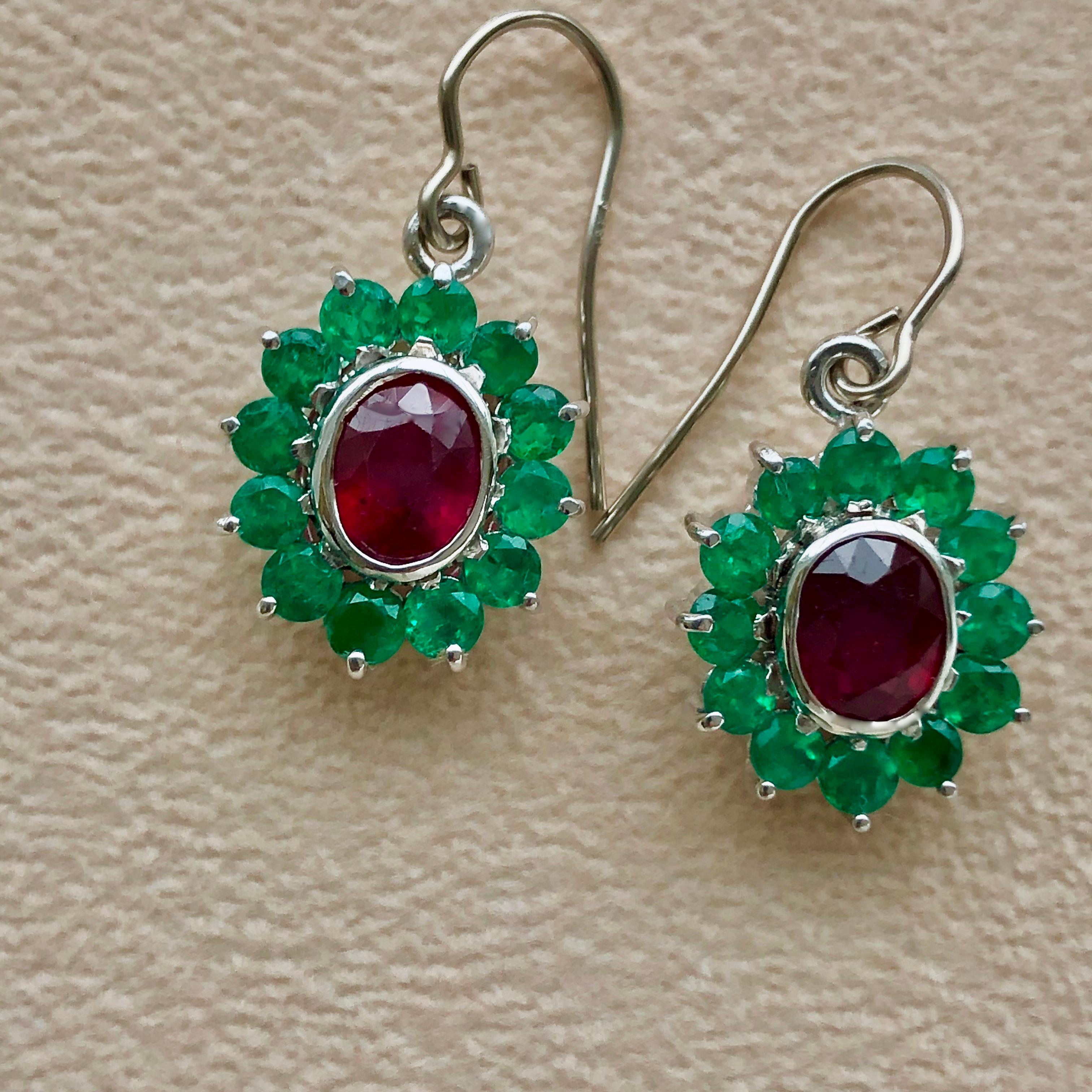 18 karat earrings with two oval cut rubies, total weight 2.90 carats (treated, heated, and filled).  And 24 round natural Colombian emeralds weighing 2.60 carats. Totaling gemstone weight of 5.50 carats. This classic style dangle earring handcrafted