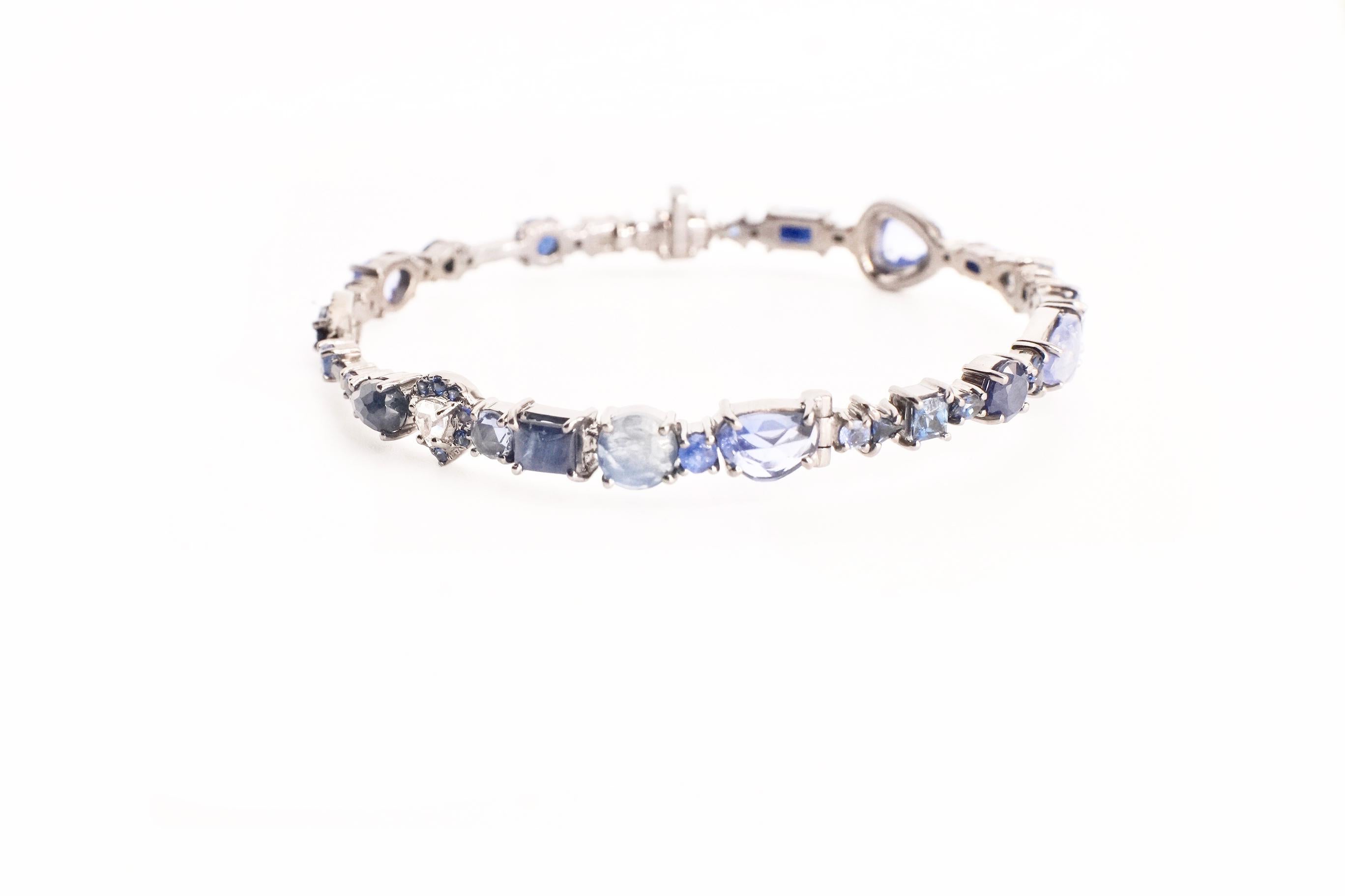 Sapphire Baby Bangle 
An eighteen-karat white gold hinged bangle set entirely with white diamonds and sapphires in a variety of shapes and sizes
Diamond Total Weight – 1.15 cts.
Gemstone Total Weight – 14.29 cts.
This piece is one-of-a-kind and