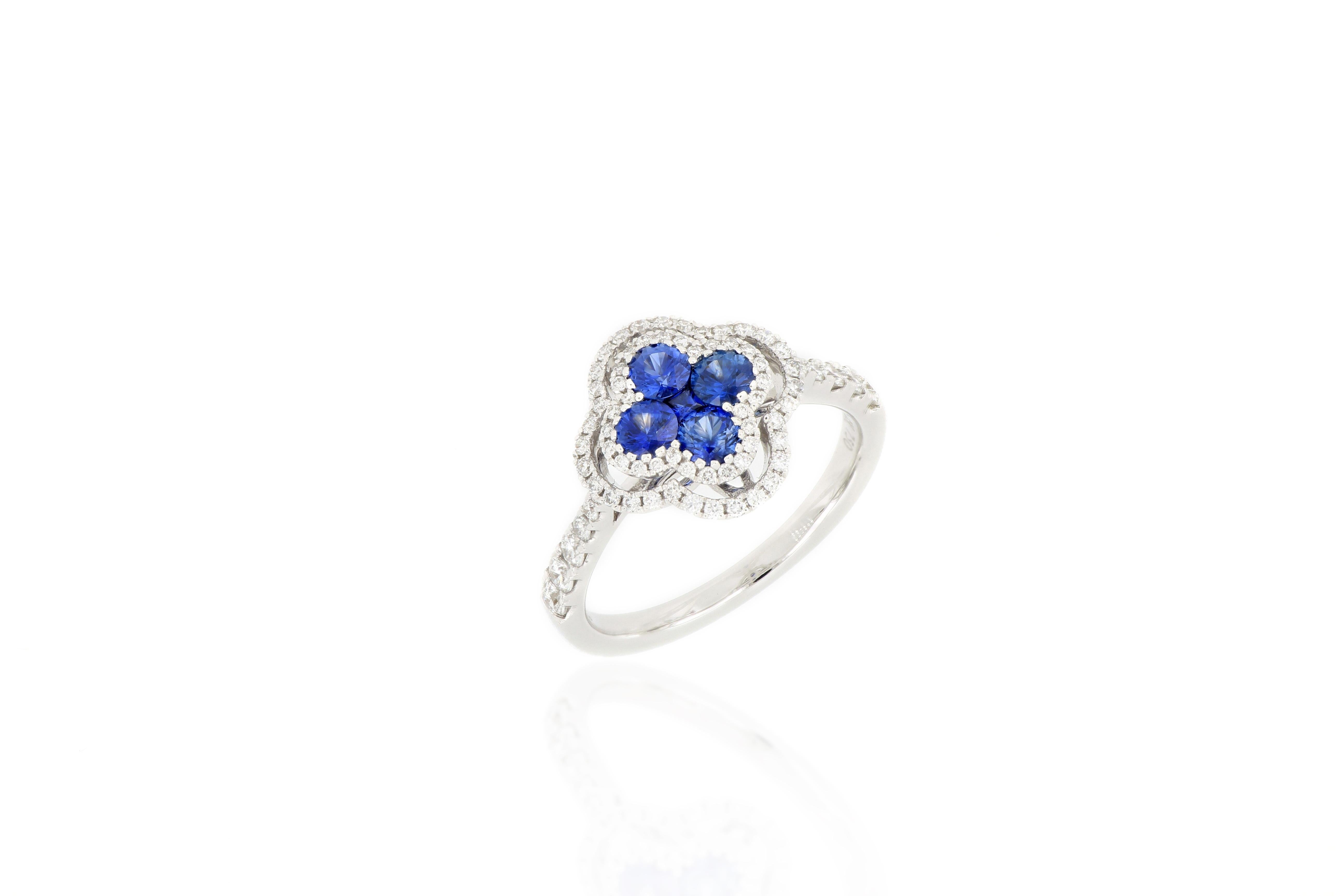 A fabulous sapphire and diamond ring. A cluster of natural sapphire arranged in the four-leaf clover pattern weighing 0.67cts, surrounded by brilliant-cut diamonds extending to the shoulders, total weighing 0.45cts, mounted in 18 karat white gold.