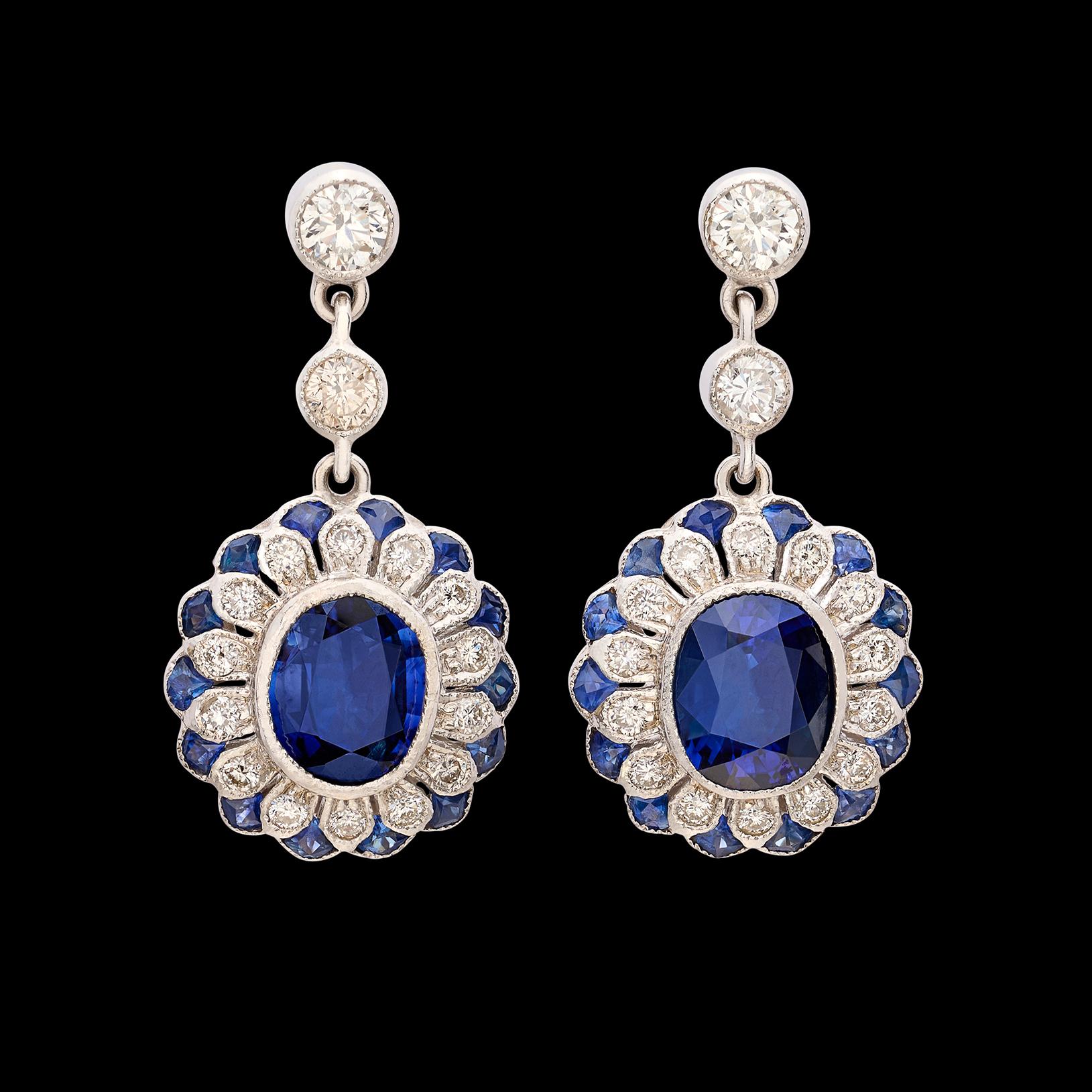 If you're looking for the perfect pair or earrings, your search may have just ended! This exceptionally beautiful 18 karat white gold drop earrings feature 2 gorgeous center sapphires weighing a total of 3.12 carats, suspended in a lovely design