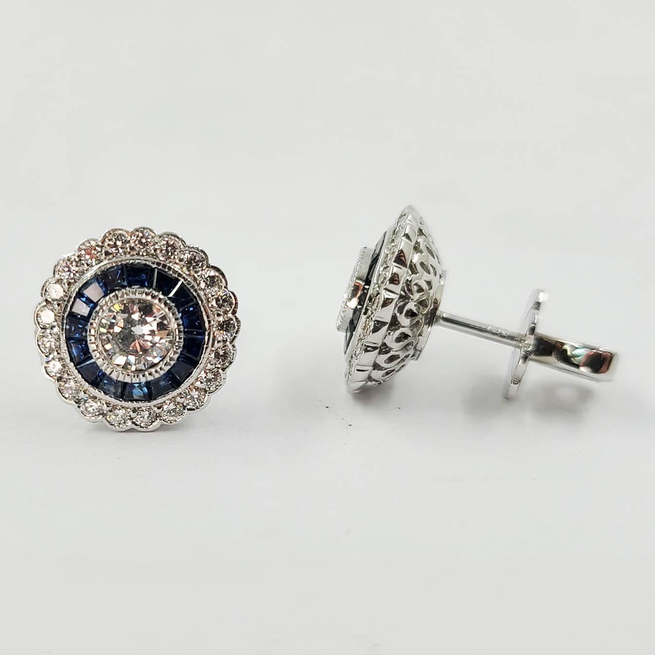 Vintage Inspired NEW 18 Karat White Gold Diamond & Sapphire Stud Earrings. 2 Round Bezel Set Diamonds Total 0.48 Carats of F Color & VS1 Clarity. 40 Round Diamonds Total 0.50 Carats & 30 Specialty Cut Blue Sapphires Total 0.75 Carats. Detailed