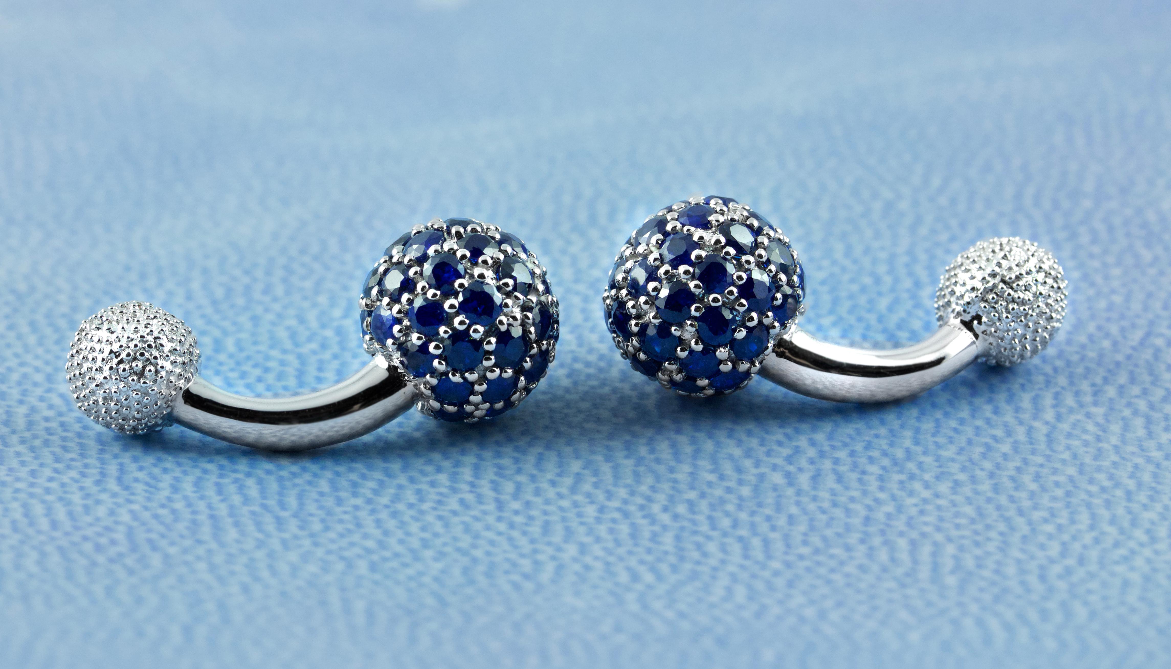 These elegant cufflinks are made entirely of 18k white gold. The large spherical front face is completely covered by sapphires , while the toggle is shaped as a smaller sphere with a multi-faceted texture.
 A curved post with a polished, smooth