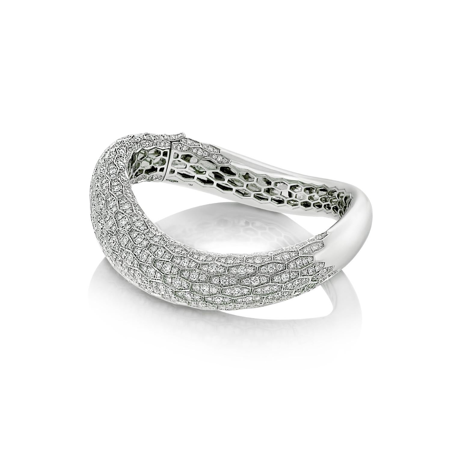 The mesmerising and entirely hand crafted form twists around the wrist with scintillating serpent scales of brilliant cut diamonds.
This Serpent Diamond Bangle Bracelet is a unique One of a Kind jewel.

Details
- 18 karat White Gold
- 8.25 carat