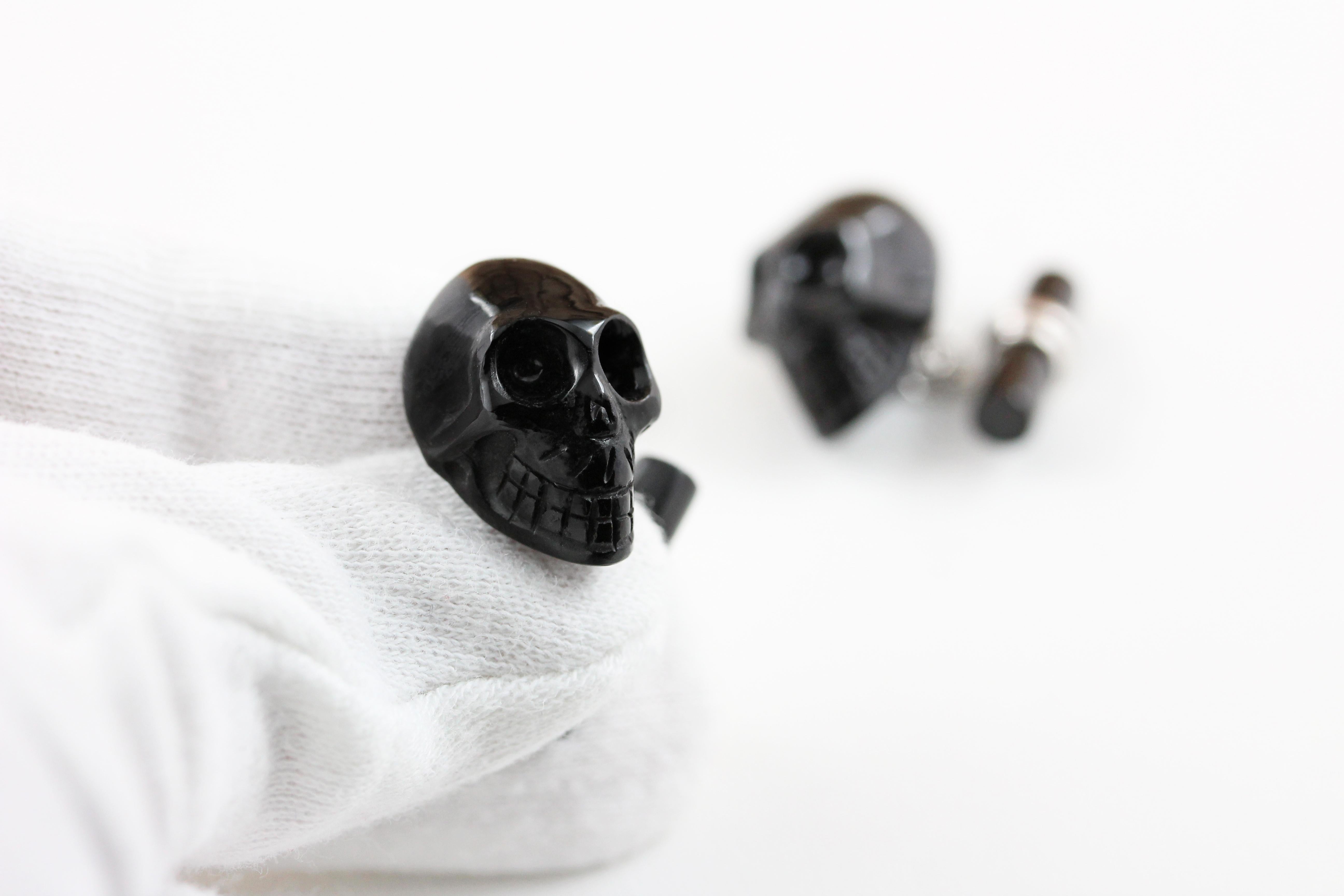 These striking cufflinks are a bold and elegant addition to any attire. 
They are made entirely of black onyx stone and, while the toggle is a simple cylinder, the front face is the protagonist of the piece, shaped as a skull with striking textures